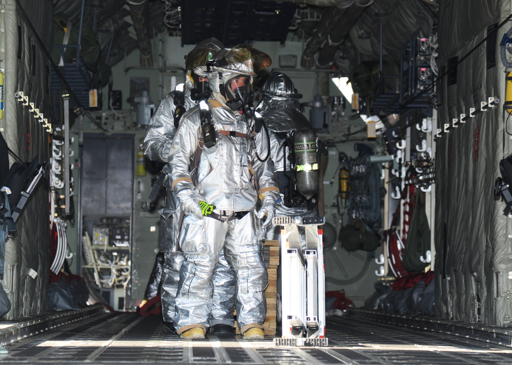 Raymond Bell, 81st Infrastructure Division firefighter, leads his team through a C-130J Hercules aircraft to search and rescue during a major accident response exercise Feb. 12, 2015, on the flight line, Keesler Air Force Base, Miss.  The MARE simulated a C-130J Hercules aircraft crash on base. Exercises are held periodically to prepare for real world emergencies.  (U.S. Air Force photo by Kemberly Groue)