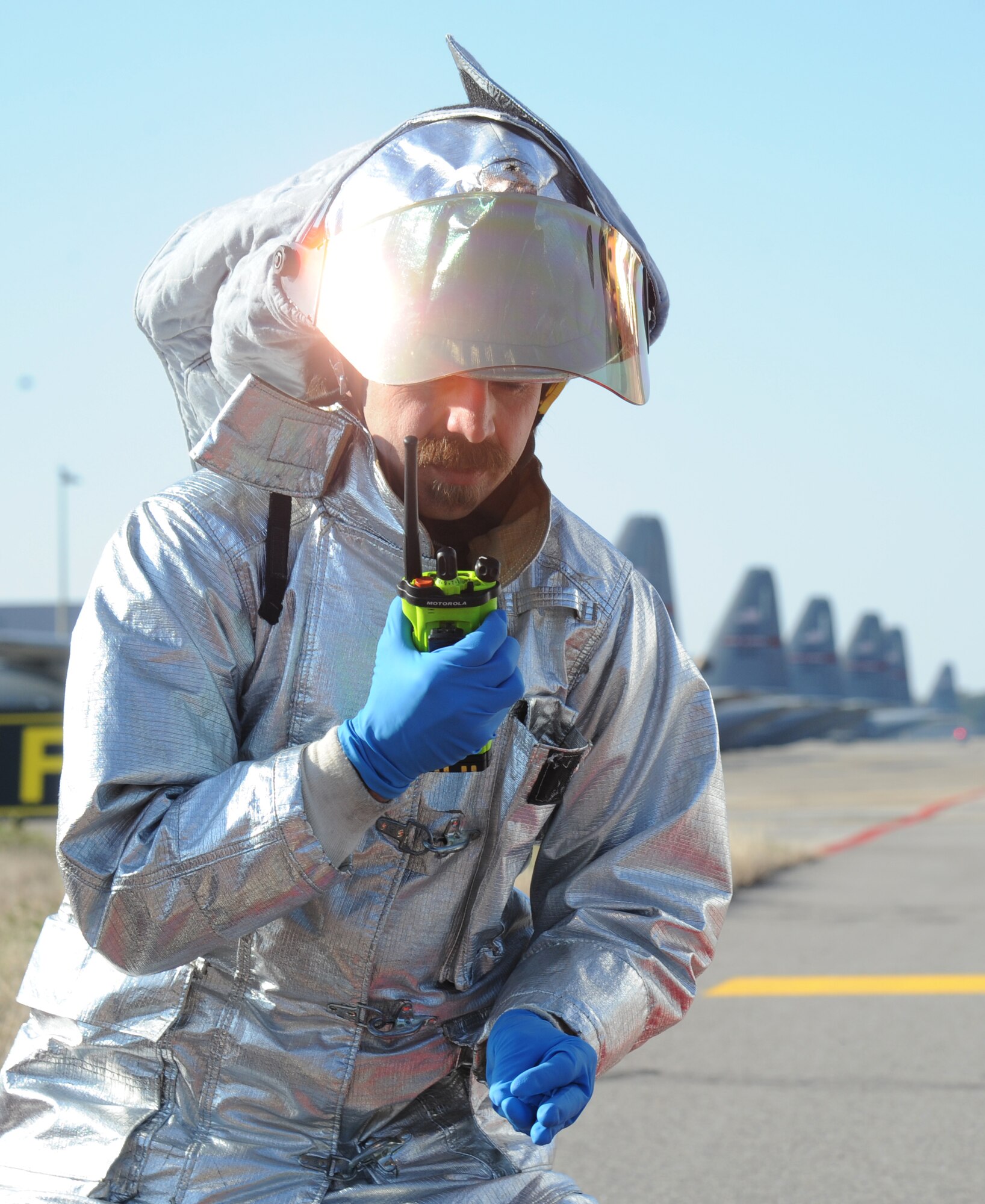 David Cleland, 81st Infrastructure Division firefighter, communicates with fellow responders during a major accident response exercise Feb. 12, 2015, on the flight line, Keesler Air Force Base, Miss.  The MARE simulated a C-130J Hercules aircraft crash on base. The exercise was held to test the readiness of Keesler personnel during a major accident.  (U.S. Air Force photo by Kemberly Groue)