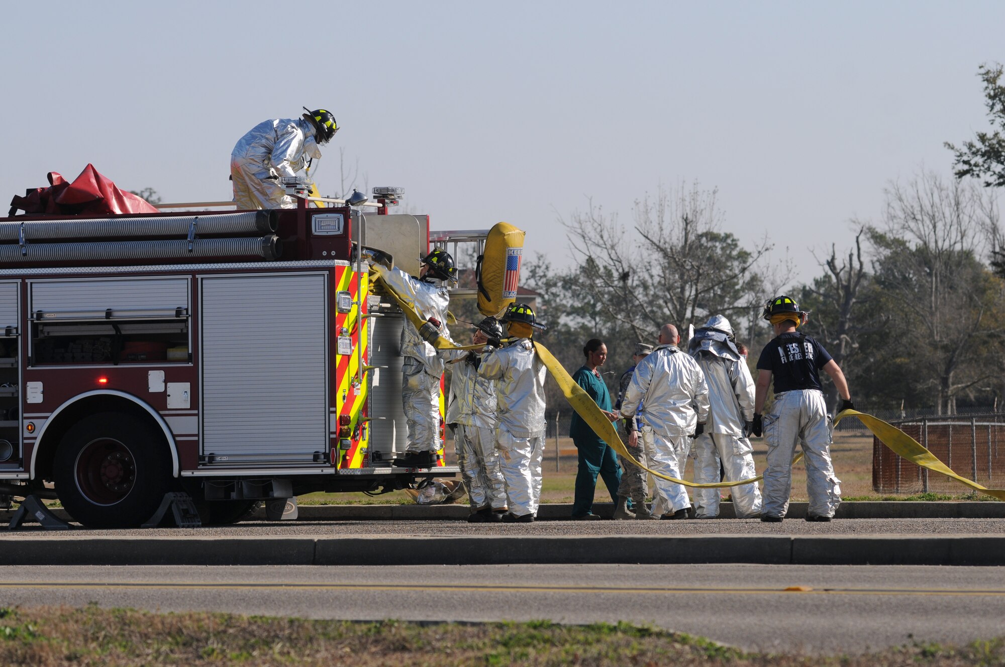 Keesler firefighters load a fire hose on to the truck after responding during a major accident response exercise Feb. 12, 2015, on the flight line, Keesler Air Force Base, Miss.  The MARE simulated a C-130J Hercules aircraft crash on base. The exercise was held to test the readiness of Keesler personnel during a major accident.  (U.S. Air Force photo by Kemberly Groue)