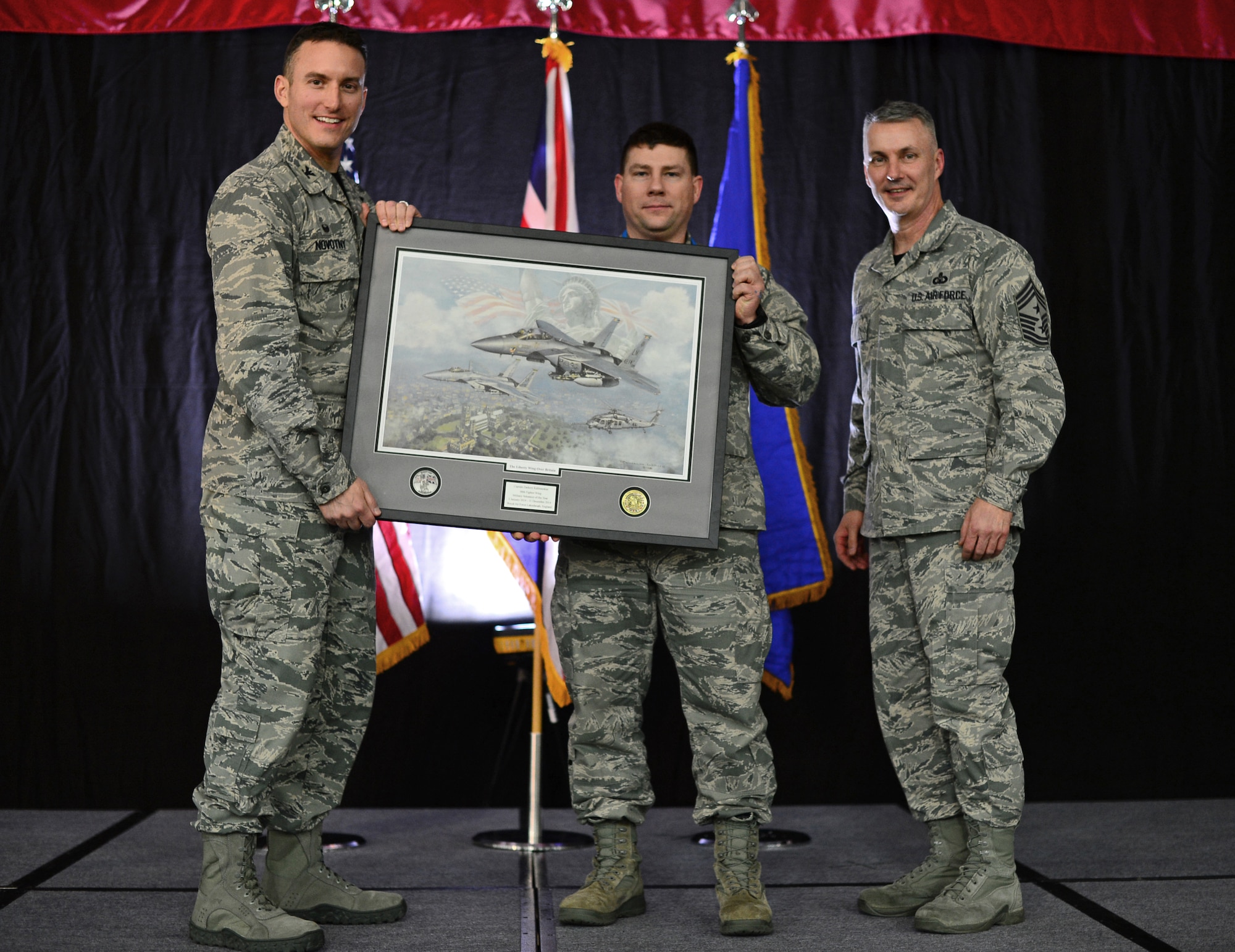 Col. Robert Novotny, 48th Fighter Wing commander, and Chief Master Sgt. Vincent Marler, 48th FW command chief, present the Military Volunteer of the Year Award to Capt. Zachery Kalinauskas, 48th Medical Group, during the 48th FW Annual Awards Banquet at Hangar 7, Feb. 13, 2015. Airmen were recognized across 11 categories, representing the spectrum of the Liberty Wing. (U.S. Air Force photo by Airman 1st Class Erin R. Babis)