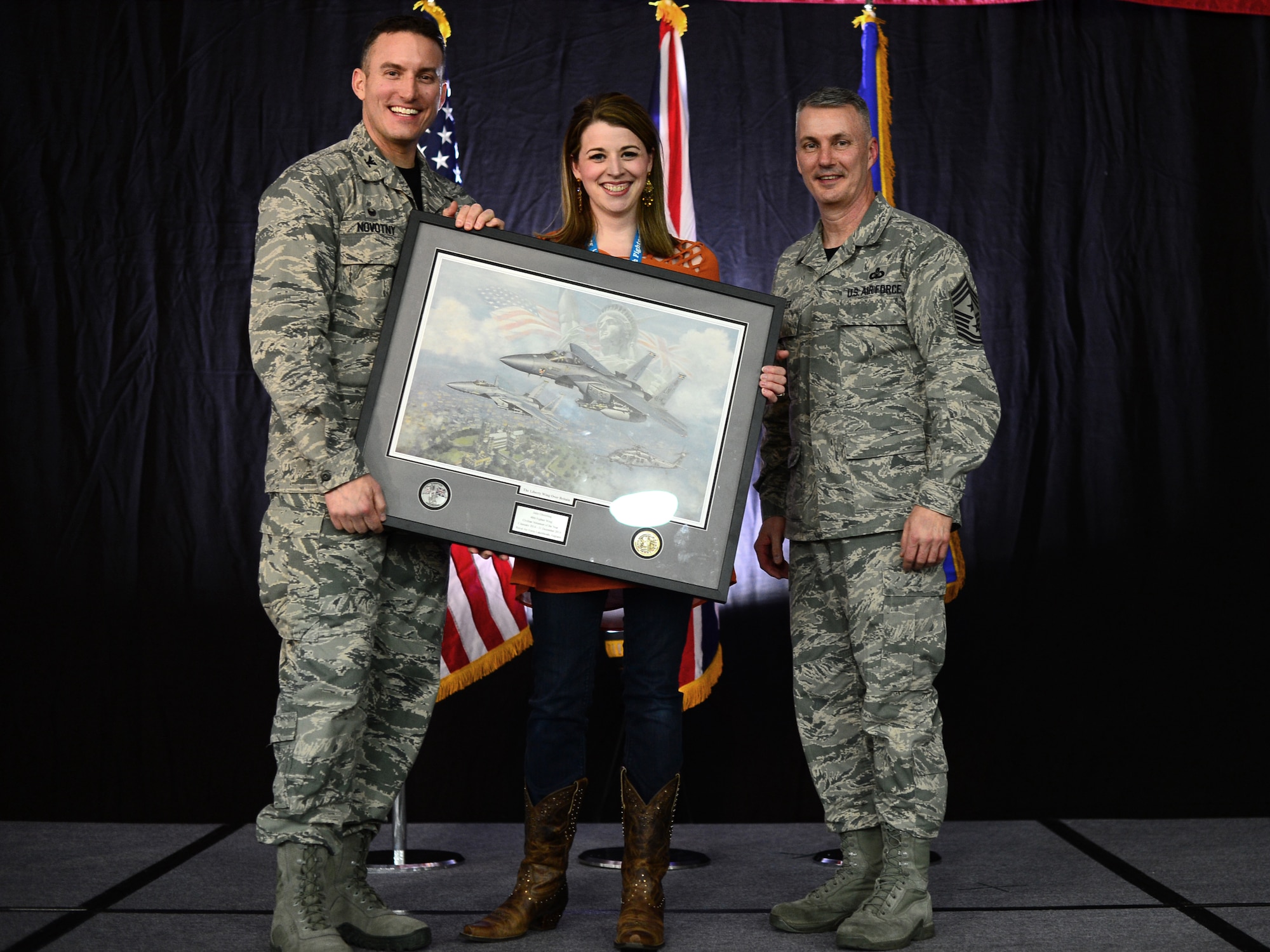 Col. Robert Novotny, 48th Fighter Wing commander, and Chief Master Sgt. Vincent Marler, 48th Fighter Wing command chief, present the Civilian Volunteer of the Year Award to Julie Gheesling, 48th Mission Support Group, during the 48th FW Annual Awards Banquet at Hangar 7, Feb. 13, 2015. Airmen were recognized across 11 categories, representing the spectrum of the Liberty Wing. (U.S. Air Force photo by Airman 1st Class Erin R. Babis)