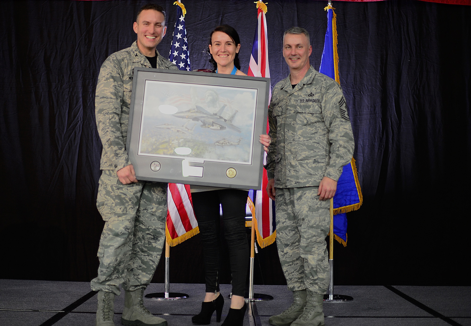 Col. Robert Novotny, 48th Fighter Wing commander, and Chief Master Sgt. Vincent Marler, 48th Fighter Wing command chief, present the Civilian of the Year, Category I Award to Tina Barnes, 48th Mission Support Group, during the 48th FW Annual Awards Banquet at Hangar 7, Feb. 13, 2015. Airmen were recognized across 11 categories, representing the spectrum of the Liberty Wing. (U.S. Air Force photo by Airman 1st Class Erin R. Babis)