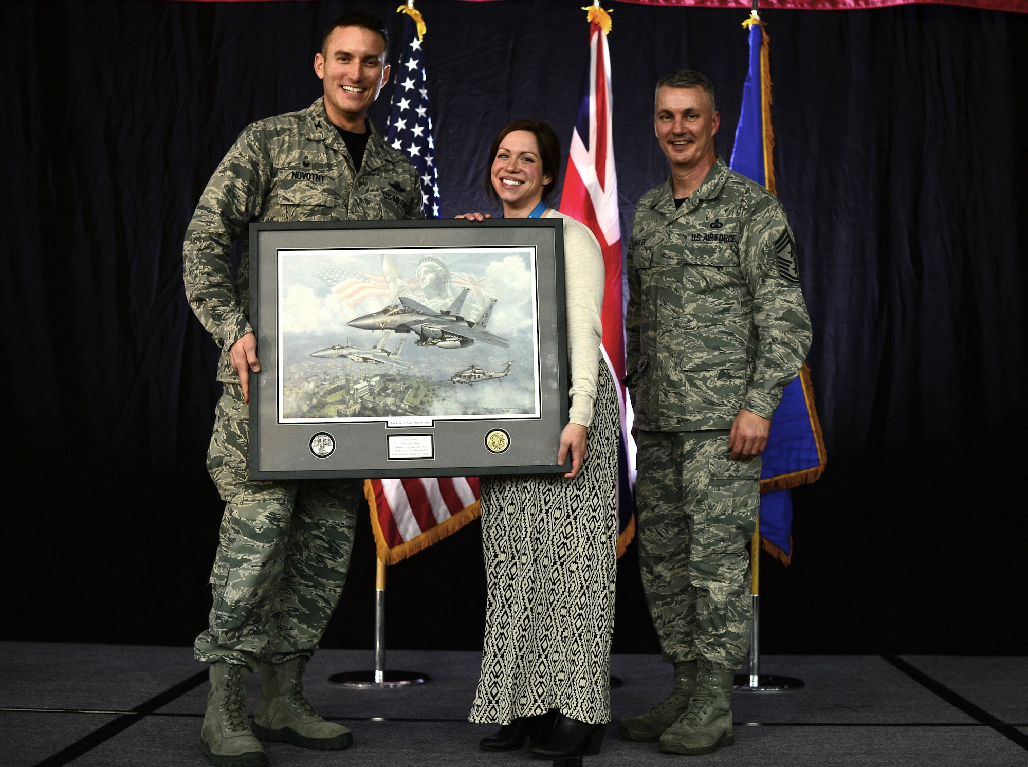 Col. Robert Novotny, 48th Fighter Wing commander, and Chief Master Sgt. Vincent Marler, 48th Fighter Wing command chief, present the Civilian of the Year, Category II Award to Ashley Sadorra, 48th Mission Support Group, during the 48th FW Annual Awards Banquet at Hangar 7, Feb. 13, 2015. Airmen were recognized across 11 categories, representing the spectrum of the Liberty Wing. (U.S. Air Force photo by Airman 1st Class Erin R. Babis)