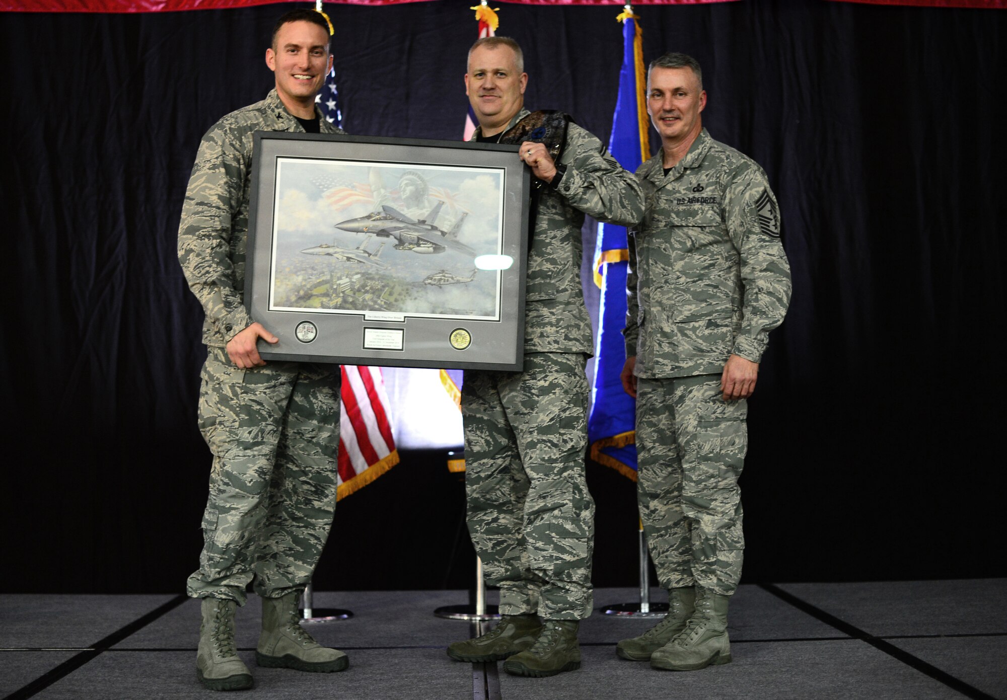 Col. Robert Novotny, 48th Fighter Wing commander, and Chief Master Sgt. Vincent Marler, 48th Fighter Wing command chief, present the First Sergeant of the Year Award to Senior Master Sgt. Matthew Moore, 48th Mission Support Group, during the 48th FW Annual Awards Banquet at Hangar 7, Feb. 13, 2015. Airmen were recognized across 11 categories, representing the spectrum of the Liberty Wing. (U.S. Air Force photo by Airman 1st Class Erin R. Babis)