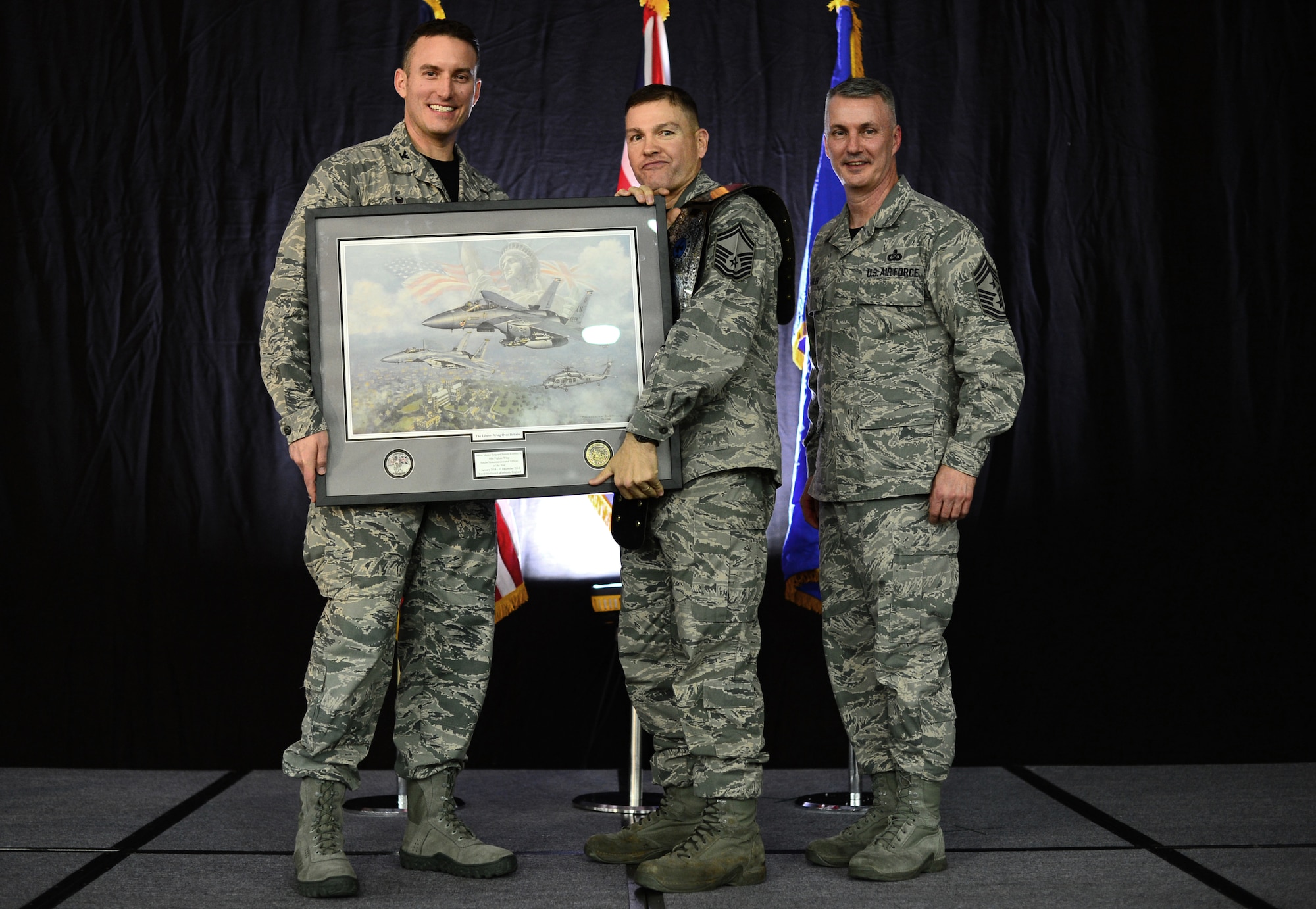 Col. Robert Novotny, 48th Fighter Wing commander, and Chief Master Sgt. Vincent Marler, 48th Fighter Wing command chief, present the Senior NCO of the Year Award to Senior Master Sgt. Steven Koehler, 48th Mission Support Group, during the 48th FW Annual Awards Banquet at Hangar 7, Feb. 13, 2015. Airmen were recognized across 11 categories, representing the spectrum of the Liberty Wing. (U.S. Air Force photo by Airman 1st Class Erin R. Babis)