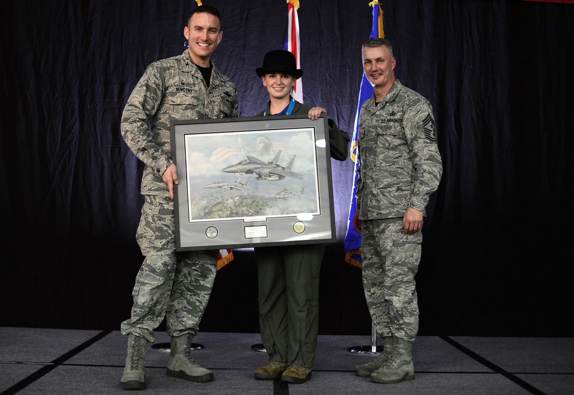 Col. Robert Novotny, 48th Fighter Wing commander, and Chief Master Sgt. Vincent Marler, 48th Fighter Wing command chief, present the Company Grade Officer of the Year Award to Capt. Valerie Annunziata, 48th Operations Group, during the 48th FW Annual Awards Banquet at Hangar 7, Feb. 13, 2015. Airmen were recognized across 11 categories, representing the spectrum of the Liberty Wing. (U.S. Air Force photo by Airman 1st Class Erin R. Babis)