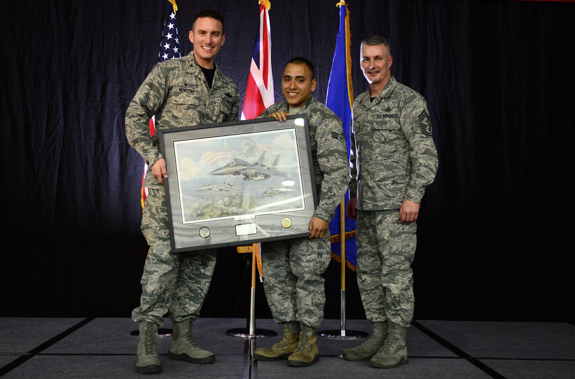 Col. Robert Novotny, 48th Fighter Wing commander, and Chief Master Sgt. Vincent Marler, 48th Fighter Wing command chief, present the Airman of the Year Award to Senior Airman Roman Contreras, 48th Operations Group, during the 48th FW Annual Awards Banquet at Hangar 7, Feb. 13, 2015. Airmen were recognized across 11 categories, representing the spectrum of the Liberty Wing. (U.S. Air Force photo by Airman 1st Class Erin R. Babis)