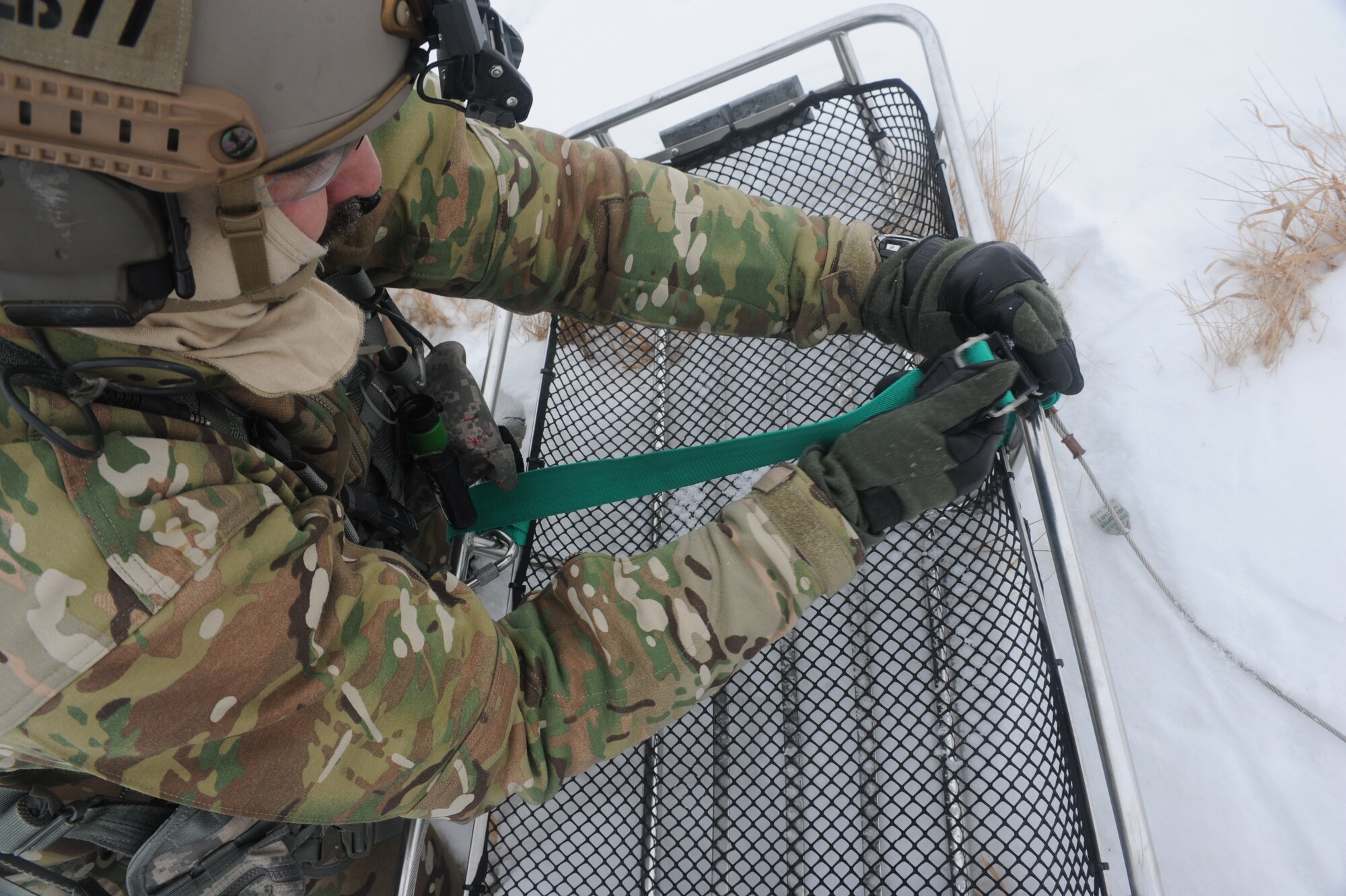 Tech. Sgt. Thomas Liscomb, 54th Helicopter Squadron flight engineer, assembles a litter near Minot Air Force Base, N.D., Feb. 11, 2015. The litter was used during training to test the crews search and rescue capabilities. (U.S. Air Force photos/Senior Airman Stephanie Morris)