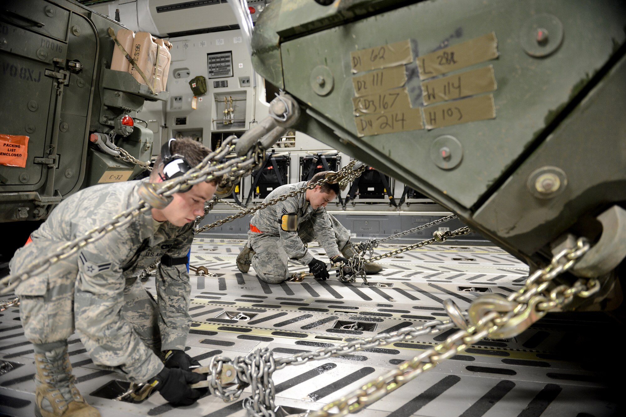 Airman 1st Class Dylan Robinson (left), and Senior Airman Mark Gates, 62nd Aerial Port Squadron air transportation technicians, tie down a M1126 Stryker combat vehicle Feb. 4, 2015, during Exercise SNAPSHOT at Joint Base Lewis-McChord, Wash. Airmen and Soldiers coordinated with each other to get the vehicles loaded onto a C-17 Globemaster III as quick as possible. (U.S. Air Force photo/Airman 1st Class Keoni Chavarria)