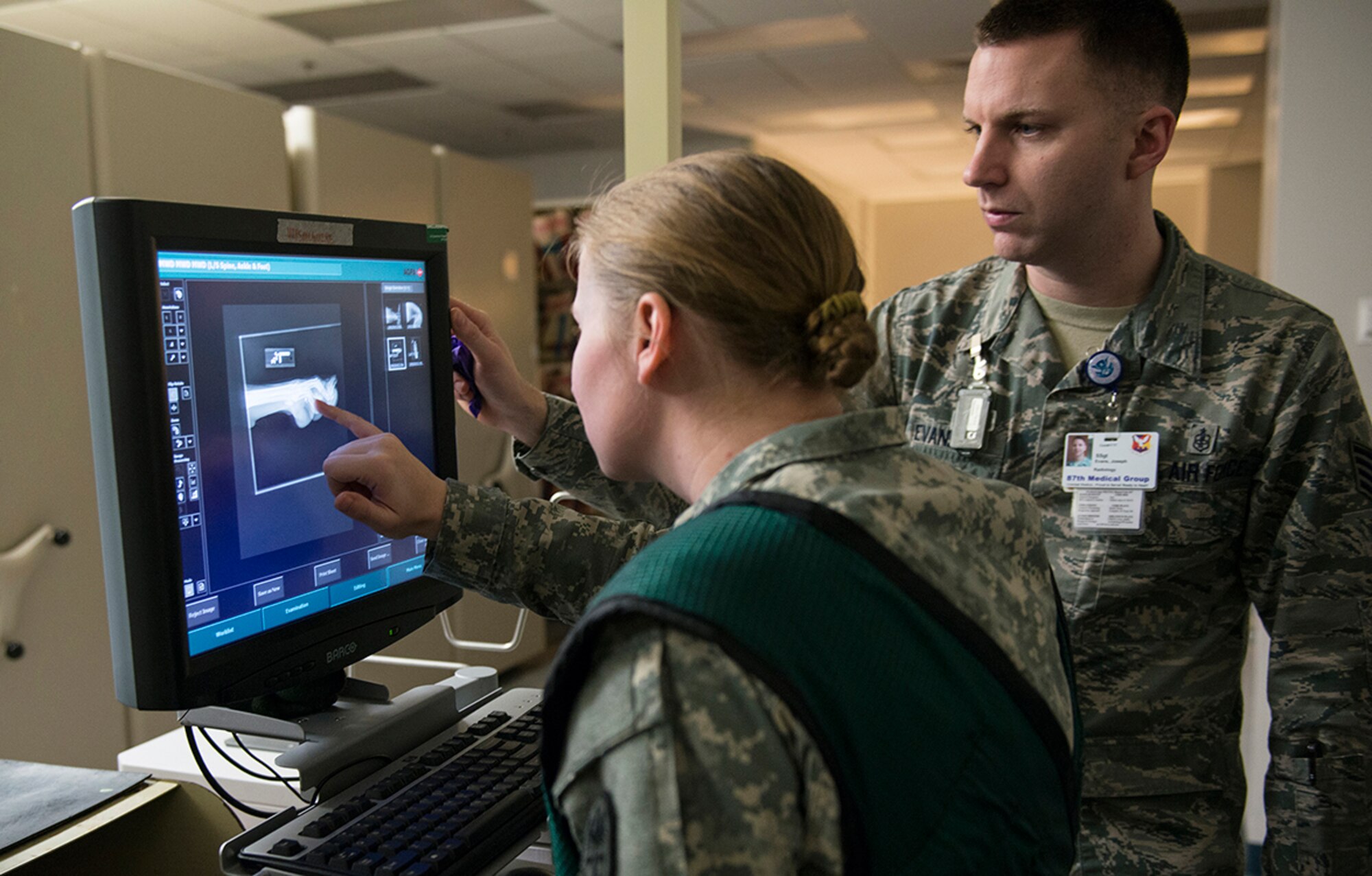 Army Capt. Kolleen Nellett, JB MDL Veterinary Services Branch chief, and Air Force Staff Sgt. Joseph Evans, 87th Medical Group radiology technologist, view an X-ray taken of Brix, a military working dog, at the radiology clinic on Joint Base McGuire-Dix-Lakehurst, New Jersey, Feb. 9, 2015. Brix is getting X-rays due to a condition called chronic lameness, which could cause him to be retired. (U.S. Air Force photo by Joshua D. King/ Released)