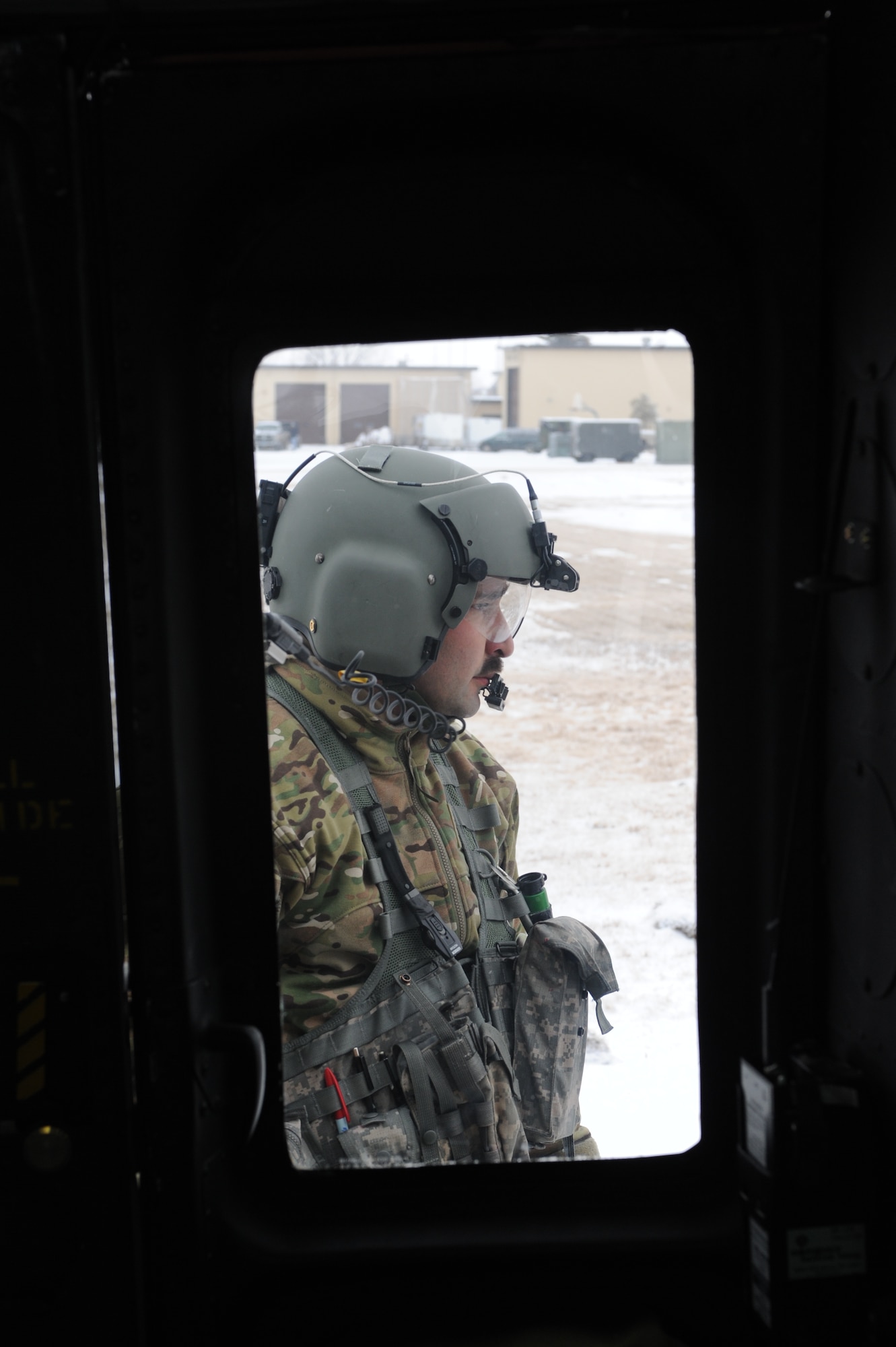 Tech. Sgt. Thomas Liscomb, 54th Helicopter Squadron flight engineer, waits near a UH1-N helicopter before a training mission on Minot Air Force Base, N.D., Feb. 11, 2015. Before the training mission, Liscomb ensured everything from the propellers to the engines were flight-ready. (U.S. Air Force photos/Senior Airman Stephanie Morris)