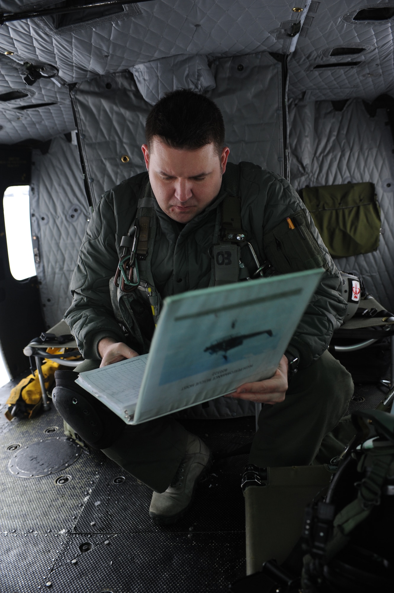 Master Sgt. Austin Atkinson, 54th Helicopter Squadron flight engineer, reviews a binder during preflight checks on a UH1-N helicopter on Minot Air Force Base, N.D., Feb. 11, 2015. During checks, Atkinson ensures that everything from the propellers to the engines were flight-ready. (U.S. Air Force photos/Senior Airman Stephanie Morris)