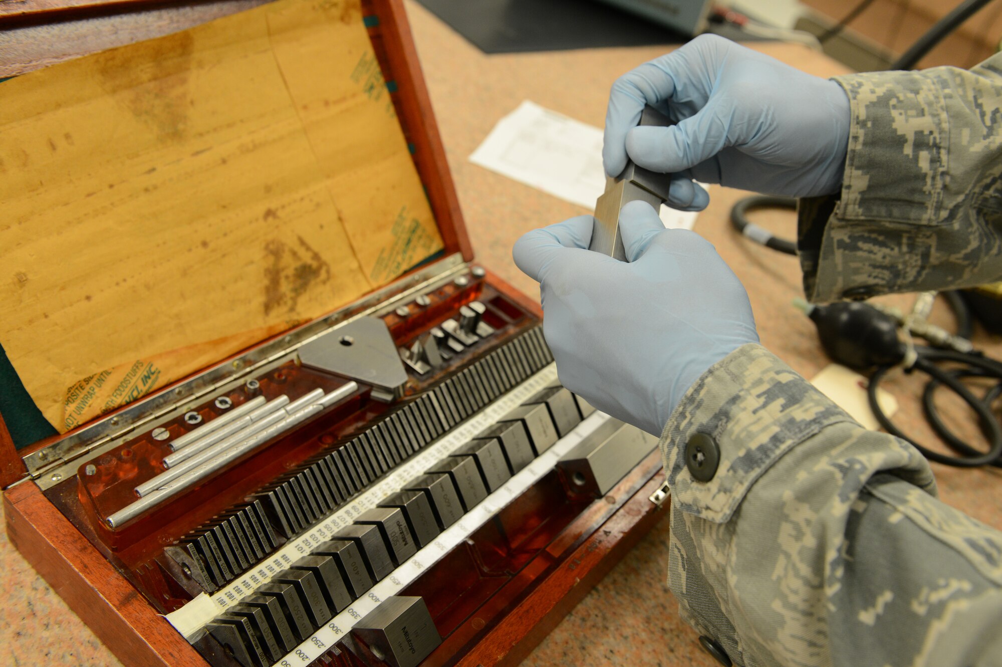 Senior Airman Donald Area, 56th CMS PMEL journeyman, demonstrates the attraction between two gage blocks. Gage blocks are measurement tools PMEL technicians use to precision measure parts. (U.S. Air Force photo/Senior Airman James Hensley)