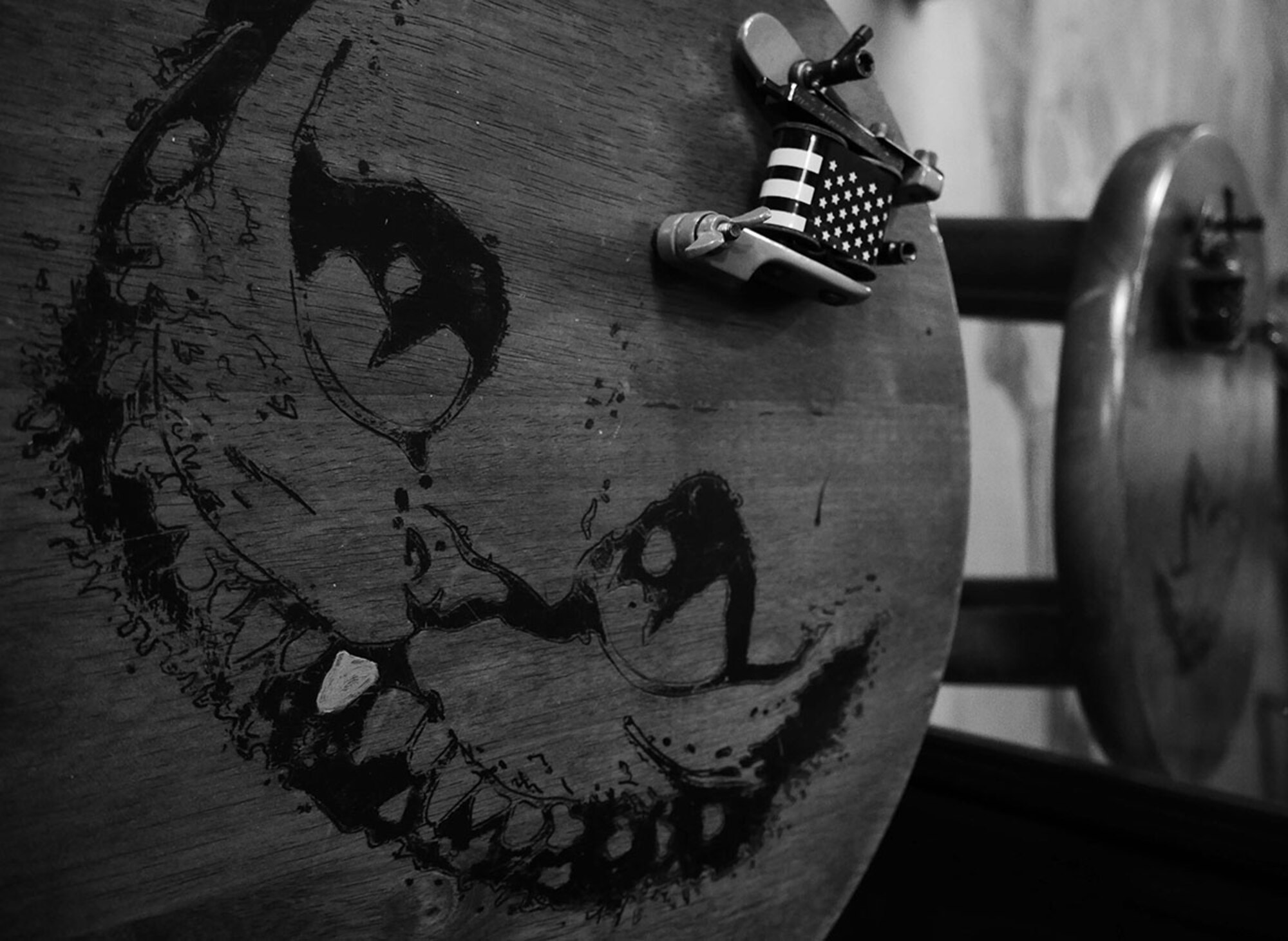 The Cheshire Cat smiles around Air Force Master Sgt. Roger Sparks’ tattoo machine. The cat has been adopted as a mascot by the pararescuemen of the 212th Rescue Squadron. (U.S. Air Force photo/Airman 1st Class Kyle Johnson)
