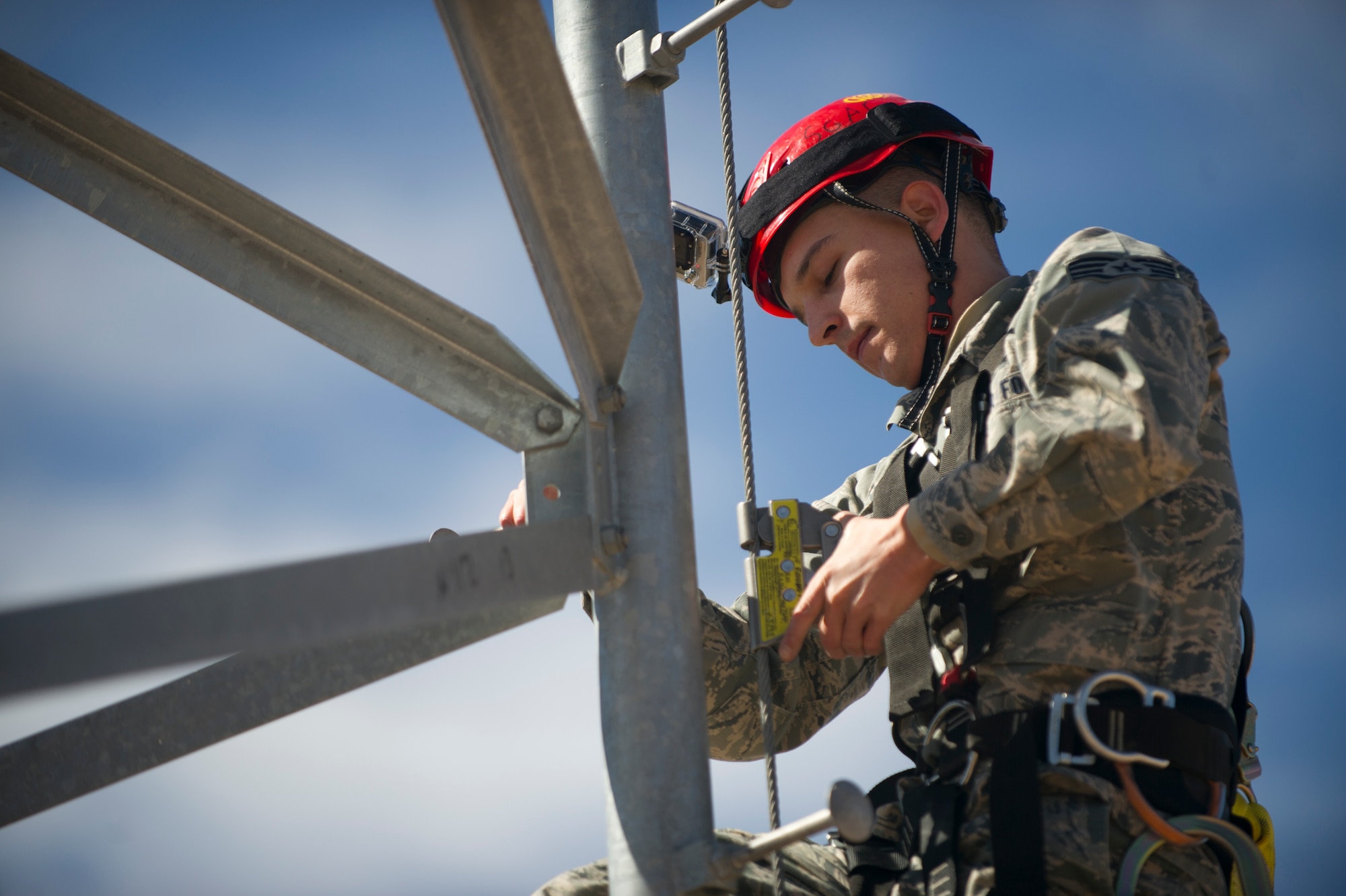 Staff Sgt. Ivan Seppala, 49th Communications Squadron Radio Frequency Transmissions Systems journeyman, demonstrates the proper way to inspect the equipment used to climb a tower Feb. 4, 2015 at Holloman Air Force Base, N.M. Seppala describes how to check for snags and tears in the harness and how to check for a manufactures date on hardhats. (U.S. Air Force photo by Staff Sgt. Stacy Moless/Released)