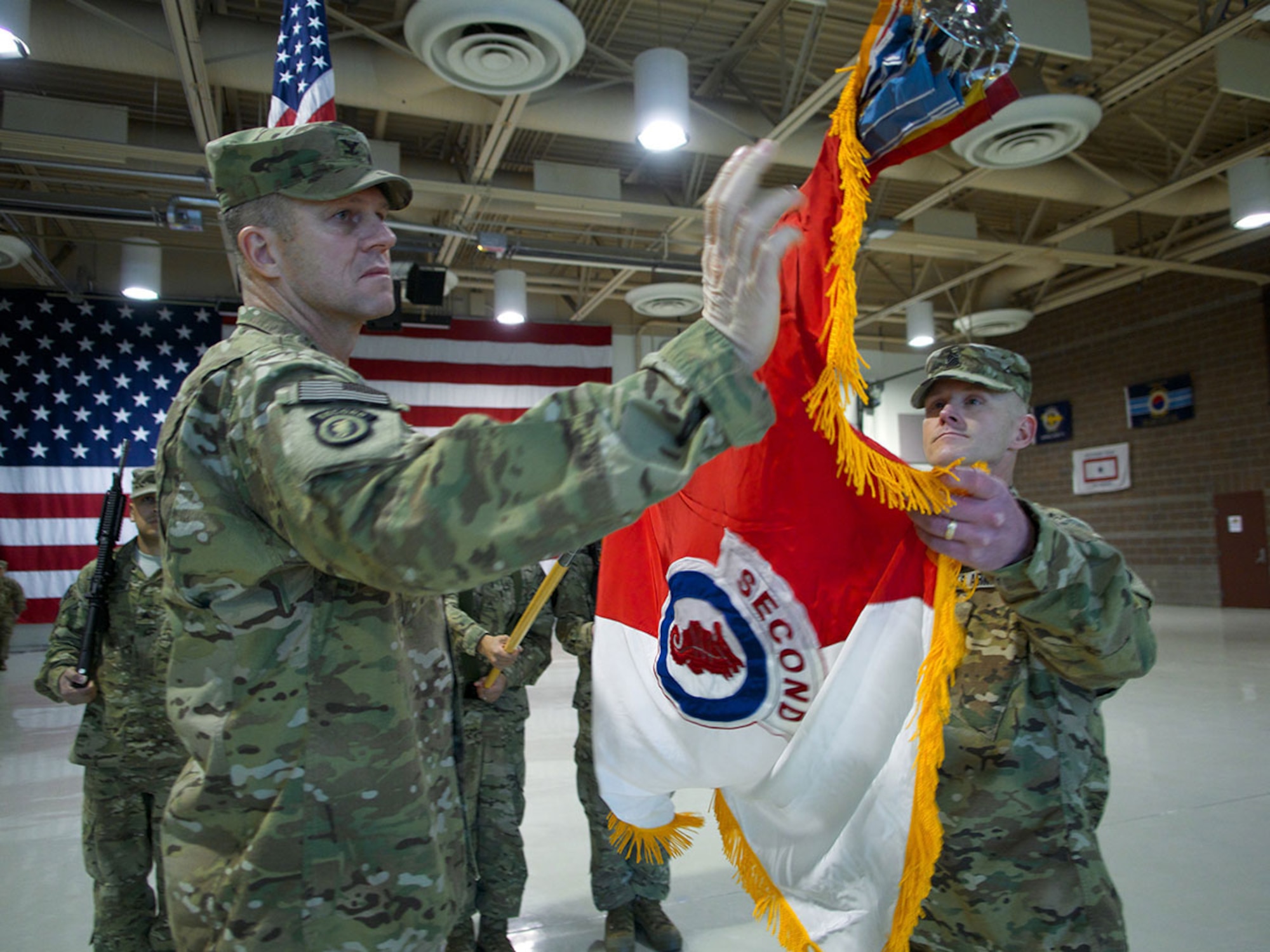 Army Col. Peter Andrysiak, 2d Engineer Brigade commander, and Command Sgt. Maj. Bradley Houston, 2d Engineer Brigade command sergeant major, uncase the unit colors during a Feb. 5 brigade redeployment ceremony at the Alaska Army National Guard Armory on Joint Base Elmendorf-Richardson. The uncasing of the colors symbolizes the brigade’s return from a seven-month deployment to Afghanistan and their reintegration with U.S. Army Alaska. (U.S. Air Force photo/David Bedard)
