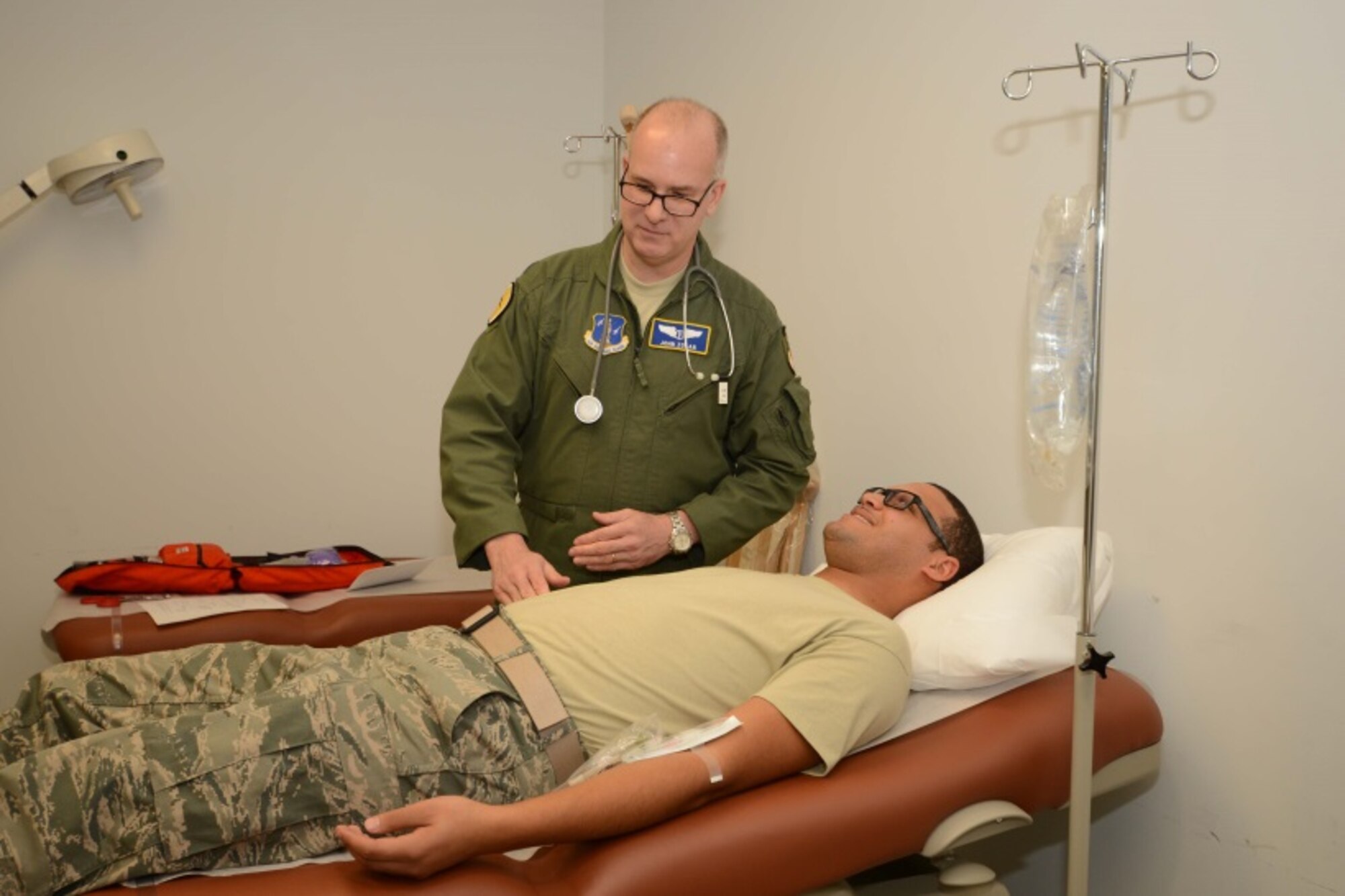 Lt. Col. John Zolan, assigned to the 103rd Medical Group, assesses Senior Air-man Gabriel Cartagena, a food services Airman assigned to the 103rd Force Support Squadron, during a public health exercise conducted at the Combat Readiness Training Center, Savannah, Ga., Jan. 5, 2015. Cartagena, a simulated flu patient, was complaining of flu-like symptoms as part of the exercise. (U.S. Air National Guard photo by Master Sgt. Erin McNamara)