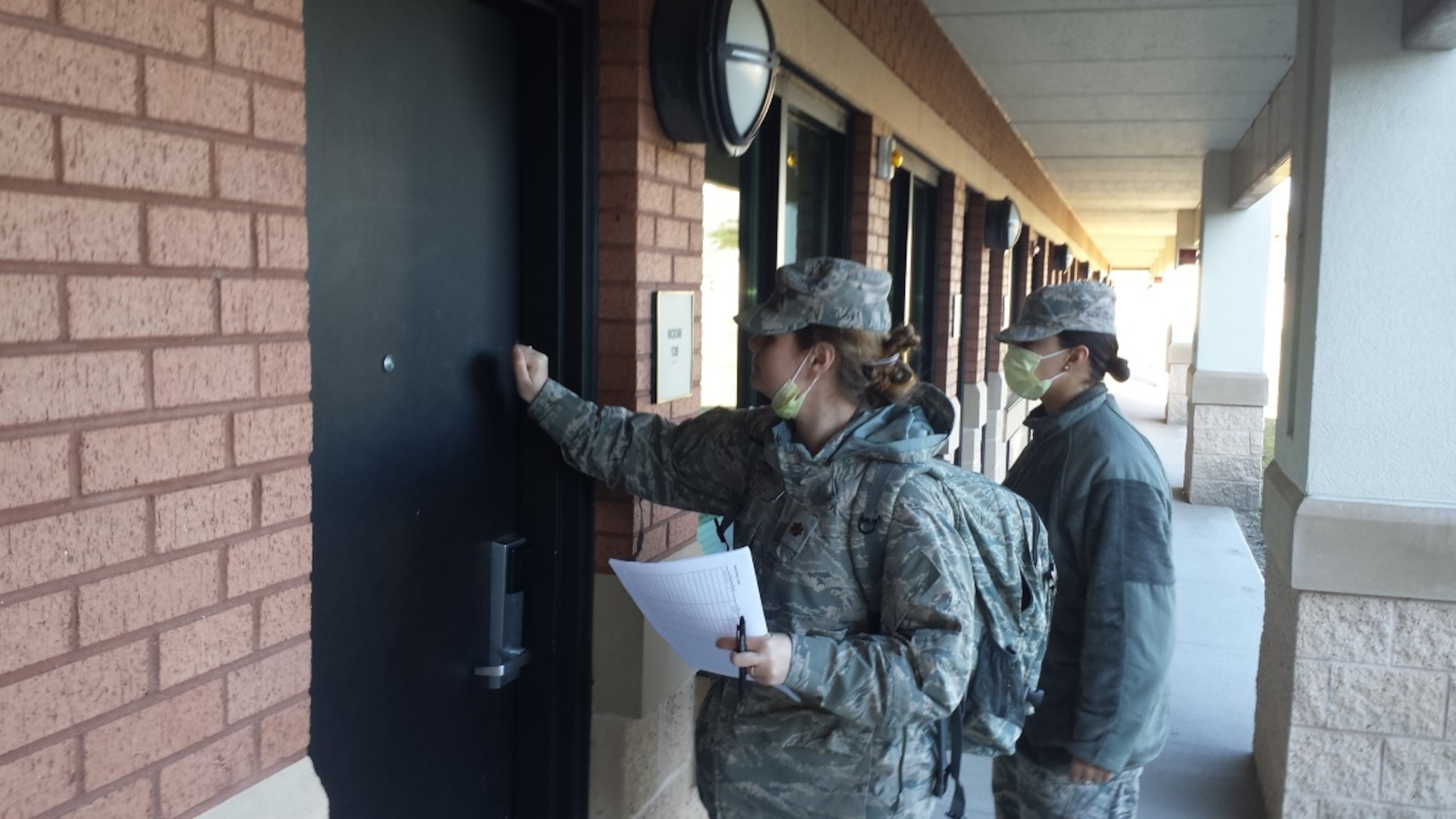 Maj. Leah Ward and Airman First Class Marissa Ruiz, both assigned to the 103rd Medical Group, conduct door-to-door house calls for all Airmen who were confined to quarters during a public health exercise at the Combat Readiness Training Center, Savannah, Ga., Jan. 7, 2015. (U.S. Air National Guard Photo by Maj. Bryon M. Turner)