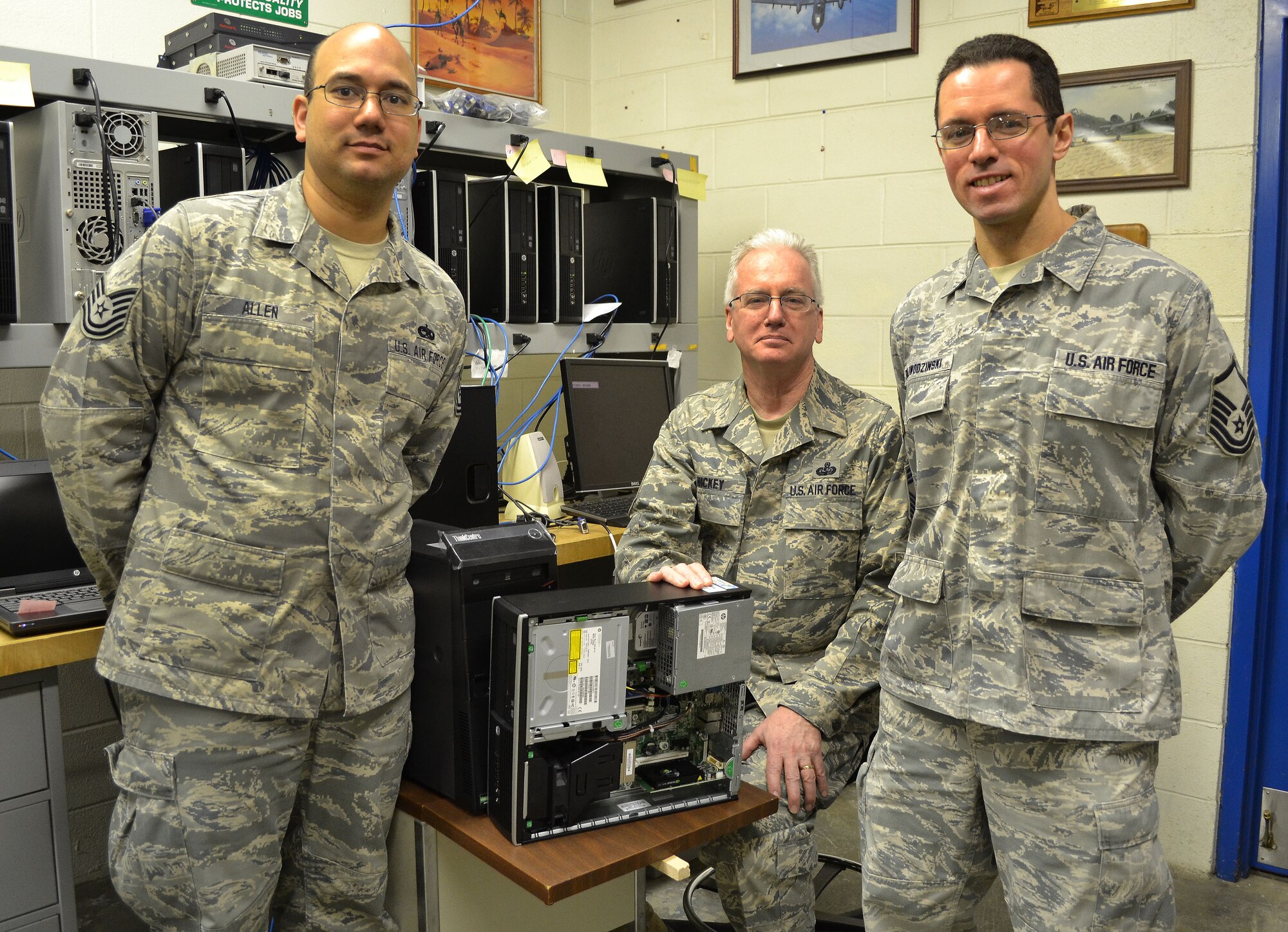 Tech. Sgt. Derrick Allen (left) Chief Master Sgt. Thomas Hickey and Master Sgt. Ken Paliwodzinski from the 111th Communications Flight stop working to take a photo Jan. 23, 2015 at Horsham Air Guard Station, Pa. The three Airmen are key technicians for the pending Air National Guard Air Force Network (AFNet) migration scheduled to begin here in March. Allen and Paliwodzinski attended Federated Administration Rights training in November, at Joint Base San Antonio-Randolph, Texas, as part of the slated program implementation. (U.S. Air National Guard photo by Master Sgt. Christopher Botzum/Released)
