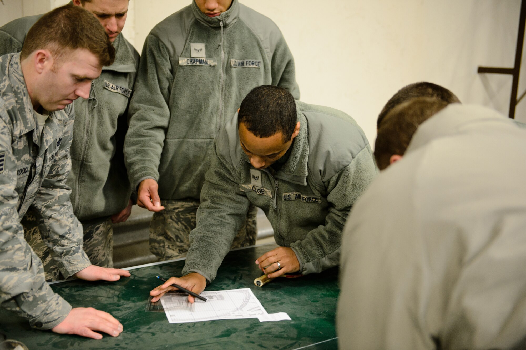 Senior Airman Raymond Cage, 86th Civil Engineer Squadron instructor, shows fellow Airmen how to plot and locate points on a map at Ramstein Air Base, Germany, Feb. 12, 2015. The engineer technician and explosive ordnance disposal Airmen trained other engineers on land navigation during their training day. (U.S. Air Force photo/Senior Airman Armando A. Schwier-Morales)