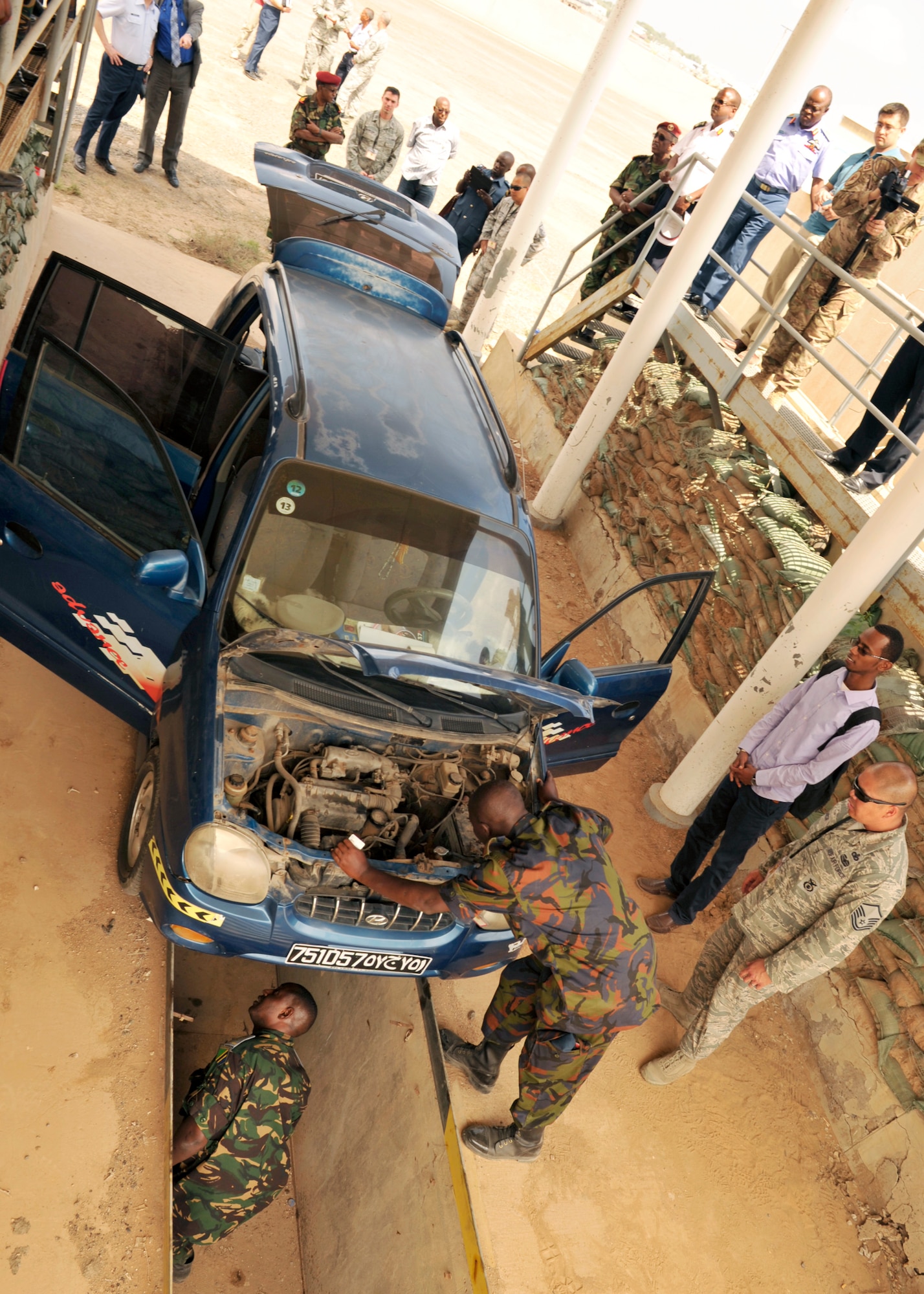 Kenya and Tanzania air force members conduct a vehicle inspection as part of an installation security knowledge exchange during African Partnership Flight???Djibouti at Djibouti Air Base, Feb. 10, 2015.  African Partnership Flight is the premiere program to bring together partner nations to increase cooperation and interoperability, which fosters stability and security throughout the continent. (U.S. Air Force Photo by Tech. Sgt. Ian Dean)