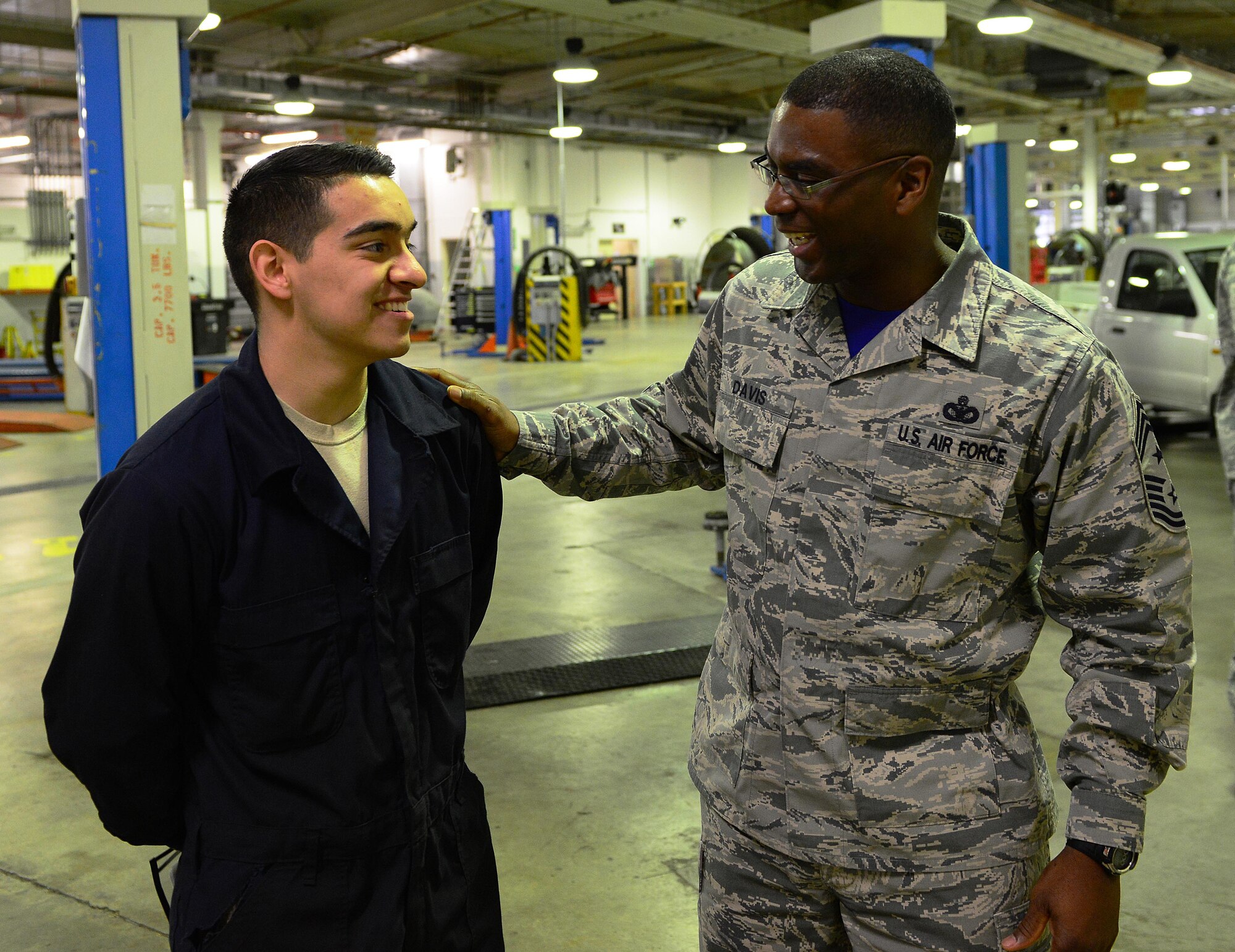 Chief Master Sgt. James Davis, U.S. Air Forces in Europe and Air Forces Africa command chief, speaks with Airman 1st Class Vincent Perez, 31st Logistics Readiness Squadron vehicle and vehicular equipment maintenance apprentice, Feb. 13, 2015, during a visit to Aviano Air Base, Italy. Davis toured several units around base and recognized outstanding Airmen. (U.S. Air Force photo by Senior Airman Matthew Lotz/Released)