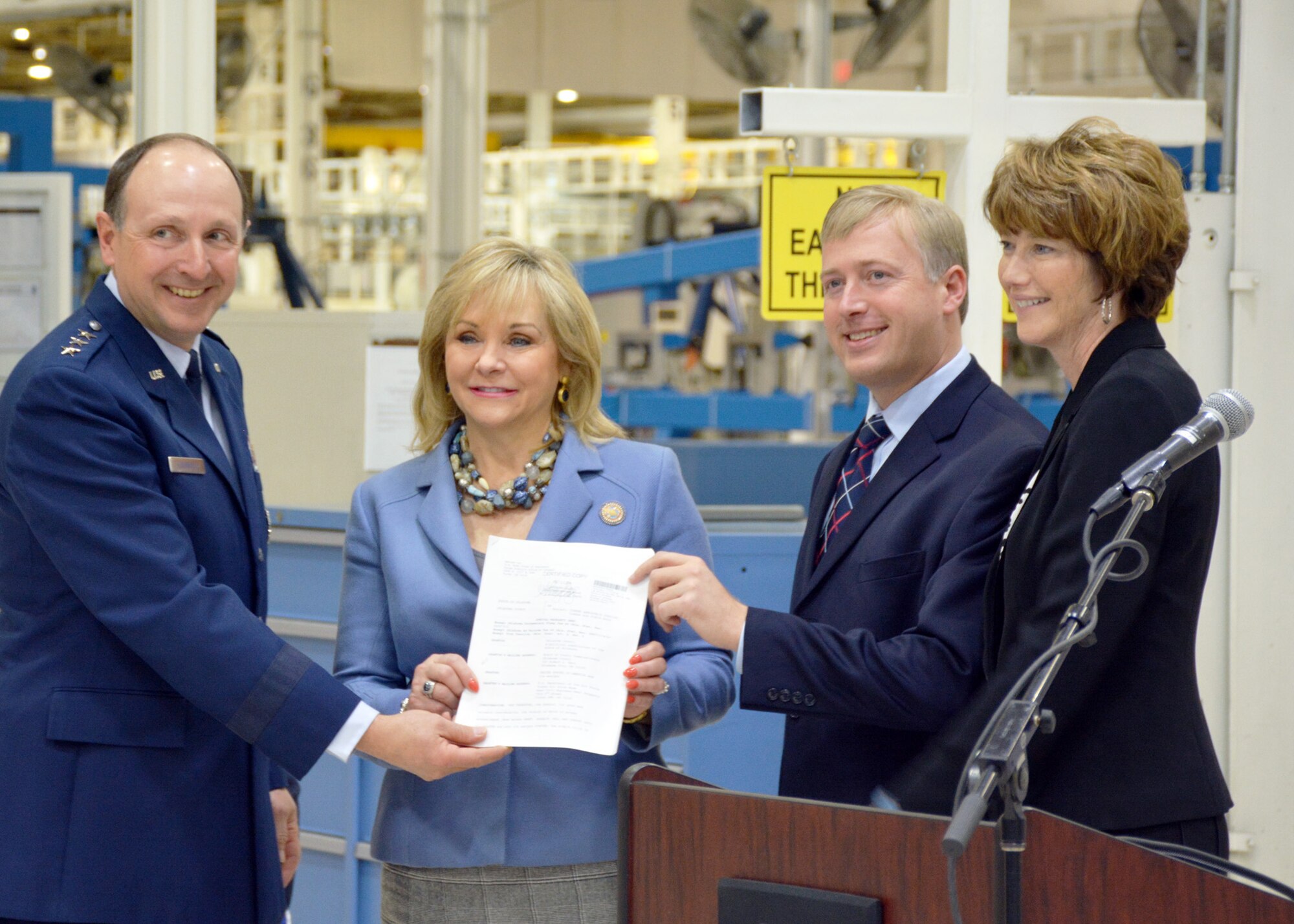 Lt. Gen. Bruce Litchfield, Air Force Sustainment Center commander, joins Oklahoma Governor Mary Fallin, Oklahoma County Commissioner Brian Maughan and Principal Deputy Assistant Secretary of the Air Force for Installations, Environment and Energy Kathleen Ferguson as they showcase the ceremonial deed to Bldg. 9001 here Feb. 4. The deed presentation was part of a joint media event held to recognize the acquisition of land to house the incoming KC-46A Pegasus depot maintenance mission and the recent transfer of the title for Bldg. 9001 from Oklahoma County to the Air Force. (Air Force photo)