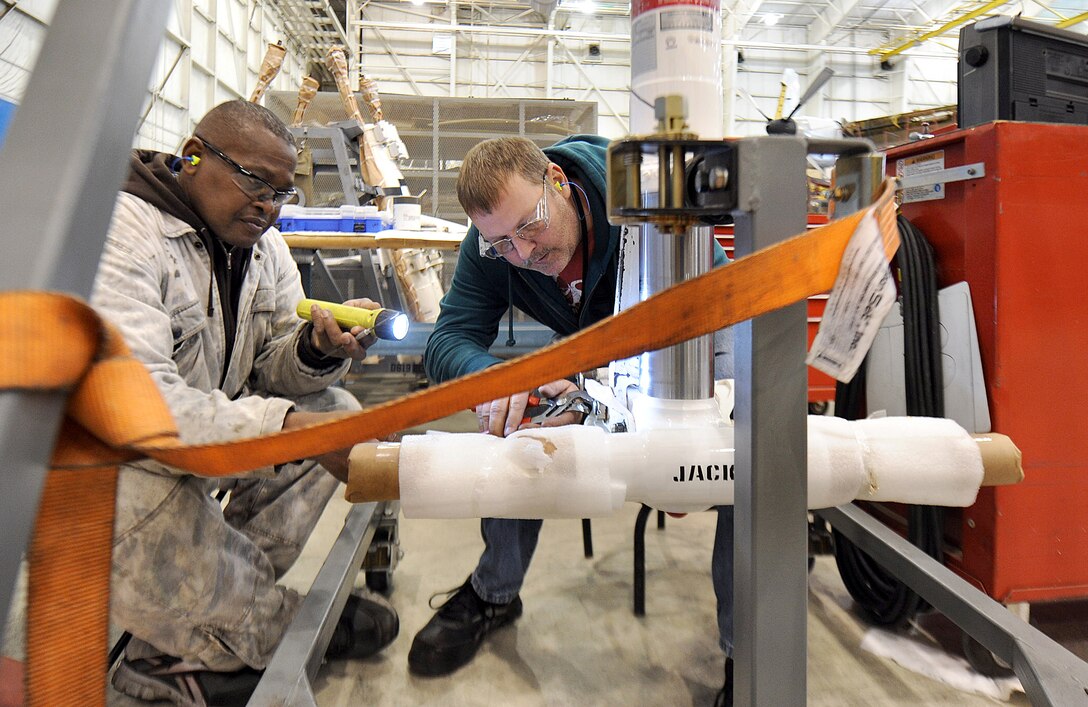 Bo Thomas and Todd Haga, 560th Aircraft Maintenance Squadron hydraulic mechanics, build up the nose landing gear of  the C-130. (U.S. Air Force photo by Tommie Horton)
