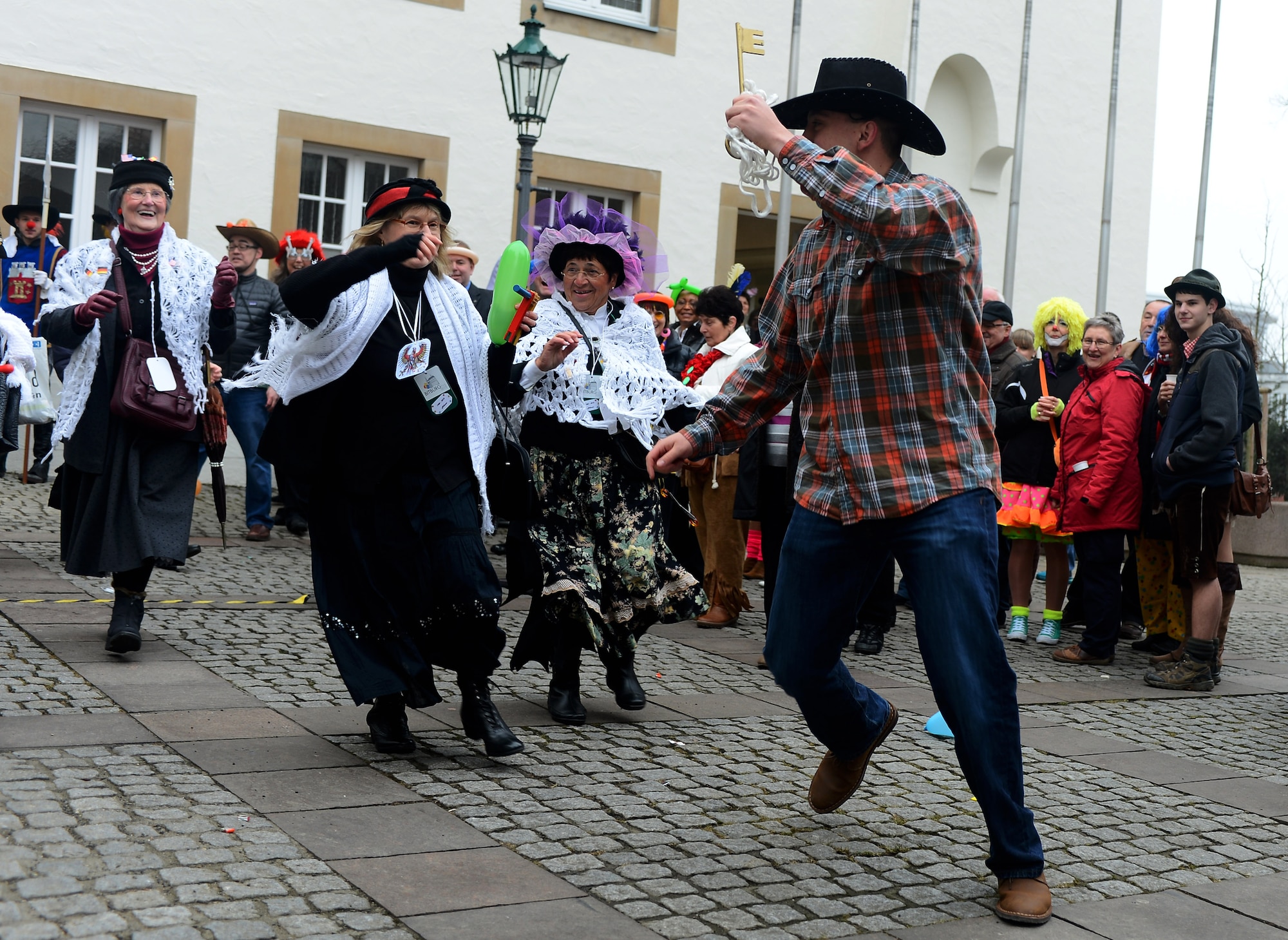 U.S. Air Force Senior Airman Dylan Nuckolls, a 52nd Fighter Wing Public Affairs photojournalist, runs with the symbolic key to the city as he is chased by female citizens of Bitburg during the 2015 Storming of the Rathaus Fasching event in Bitburg, Germany, Feb. 12, 2015. The women captured the key, symbolizing they had taken control of the city as part of the holiday’s tradition. (U.S. Air Force photo by Airman 1st Class Luke Kitterman/Released)
 
