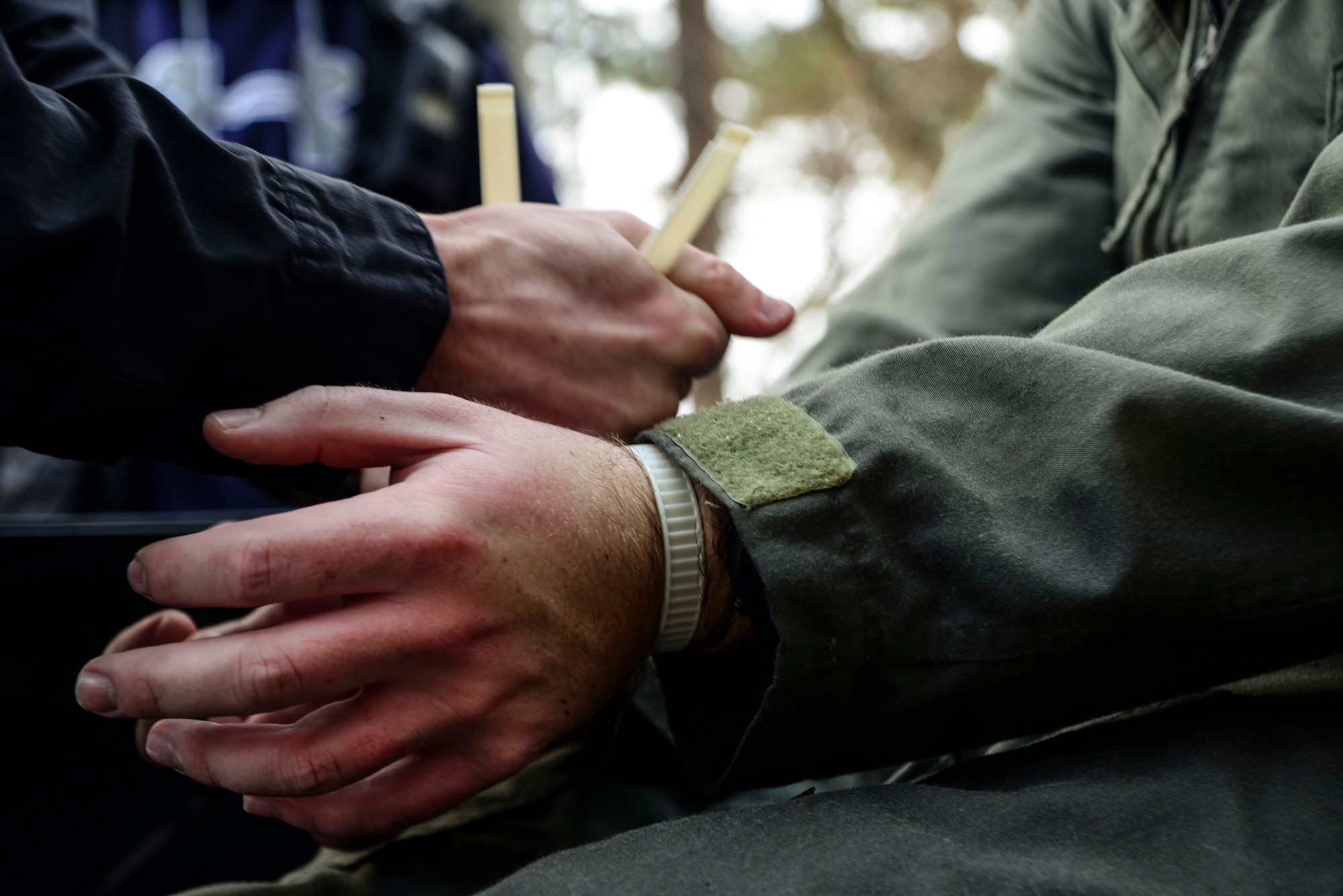 The hands of Capt. Christopher Hartman, 13th Fighter Squadron F-16 Fighting Falcon pilot, are tied by a simulated enemy combatant during a Survival, Evasion, Resistance and Escape exercise Feb. 12, 2015, at Draughon Range outside Misawa Air Base, Japan. Hartman's plane was simulated as downed in enemy territory, where he avoided enemy capture for nearly three hours. Following capture, pilots face a lengthy interrogation process. (U.S. Air Force photo by Staff Sgt. Derek VanHorn)