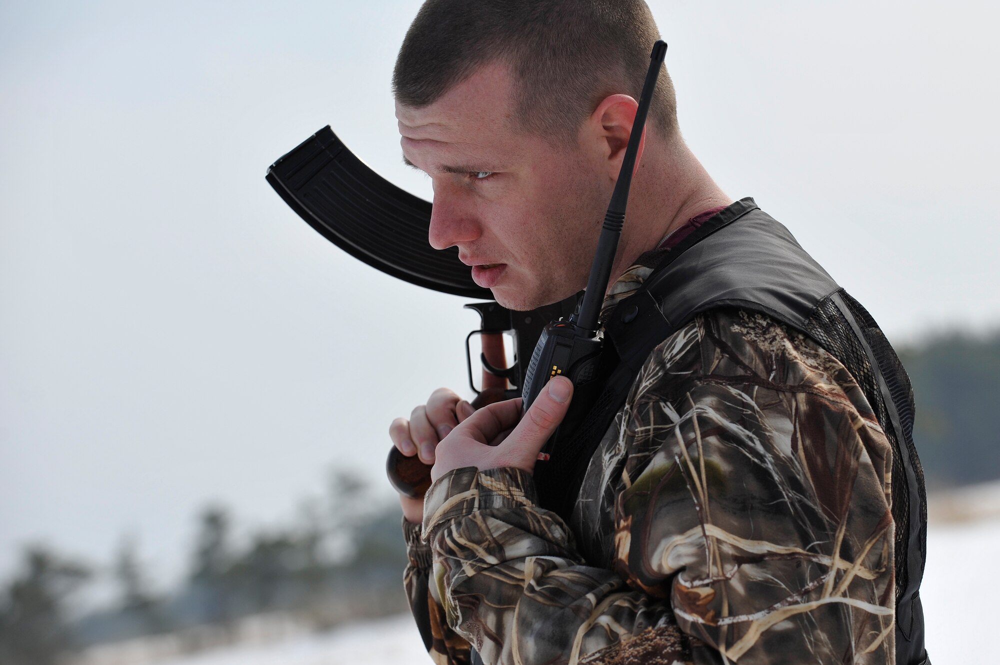 U.S. Air Force Staff Sgt. James Thompson, 35th Operations Support Squadron opposing forces member, radios in his status while in pursuit of a downed pilot during Survival, Evasion, Resistance and Escape training for pilots at the Draughon Range outside Misawa Air Base, Japan, Feb. 12, 2015. As an opposing forces member, Thompson periodically checked in with his team members to relay any important information that could lead to the capture of pilots. (U.S. Air Force photo by Senior Airman Jose L. Hernandez-Domitilo)
