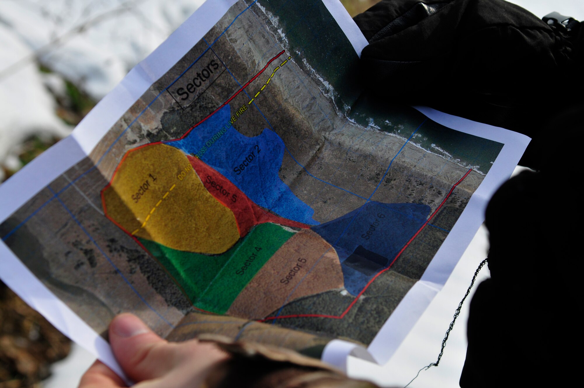 U.S. Air Force Staff Sgt. James Thompson, 35th Operations Support Squadron opposing forces member, checks his map to determine his location during Survival, Evasion, Resistance and Escape training for pilots at the Draughon Range outside Misawa Air Base, Japan, Feb. 12, 2015. Thompson was part of a two-man team of opposing forces whose objective was to capture downed pilots in an open forest area. A total of 14 two-man teams spread out throughout the Draughon Range in search of pilots. (U.S. Air Force photo by Senior Airman Jose L. Hernandez-Domitilo)