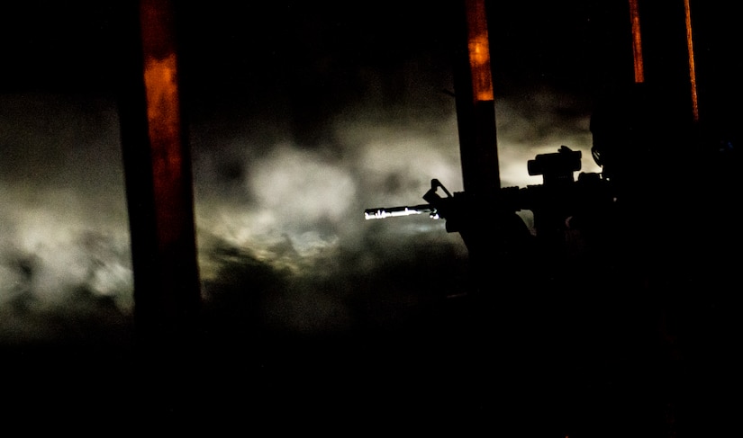 JOINT BASE CHARLESTON, S.C. – A 628th Security Forces Squadron patrolman fires downrange with only the light from his flashlight to illuminate the target during an M-4 carbine qualifying session at night at the Combat Arms Training and Maintenance firing range, Feb. 11, 2015, on Joint Base Charleston, S.C. Aside from testing Airmen’s ability to fire an M-4 carbine from several positions--prone, standing and wearing a gas mask--they are also tested in lowlight situations as well as pitch blackness, wearing Night Vision Goggles to see. (U.S. Air Force photo/ Senior Airman Dennis Sloan)