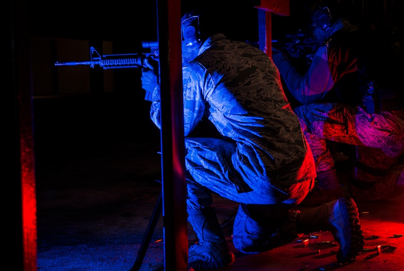 JOINT BASE CHARLESTON, S.C. – Staff Sgt. Norman Allen, 628th Security Forces Squadron patrolman, kneels, aims downrange and waits for the command to fire from Combat Arms Training and Maintenance instructors during an M-4 carbine qualifying session at night at the CATM firing range, Feb. 11, 2015, on Joint Base Charleston, S.C. As many as 15 Airmen fire simultaneously during this training, so it is crucial for the Airmen to not only hear the commands, but follow them as well. (U.S. Air Force photo/ Senior Airman Dennis Sloan)