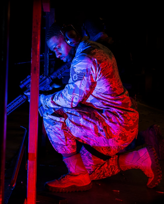 JOINT BASE CHARLESTON, S.C. – Staff Sgt. Norman Allen, 628th Security Forces Squadron patrolman, kneels down and waits for the command to fire from Combat Arms Training and Maintenance instructors during an M-4 carbine qualifying session at night at the Combat Arms Training and Maintenance firing range, Feb. 11, 2015, on Joint Base Charleston, S.C. Airmen wear two forms of ear protection to prevent damage to their eardrums, prompting CATM instructors to yell commands so all can hear. (U.S. Air Force photo/ Senior Airman Dennis Sloan)