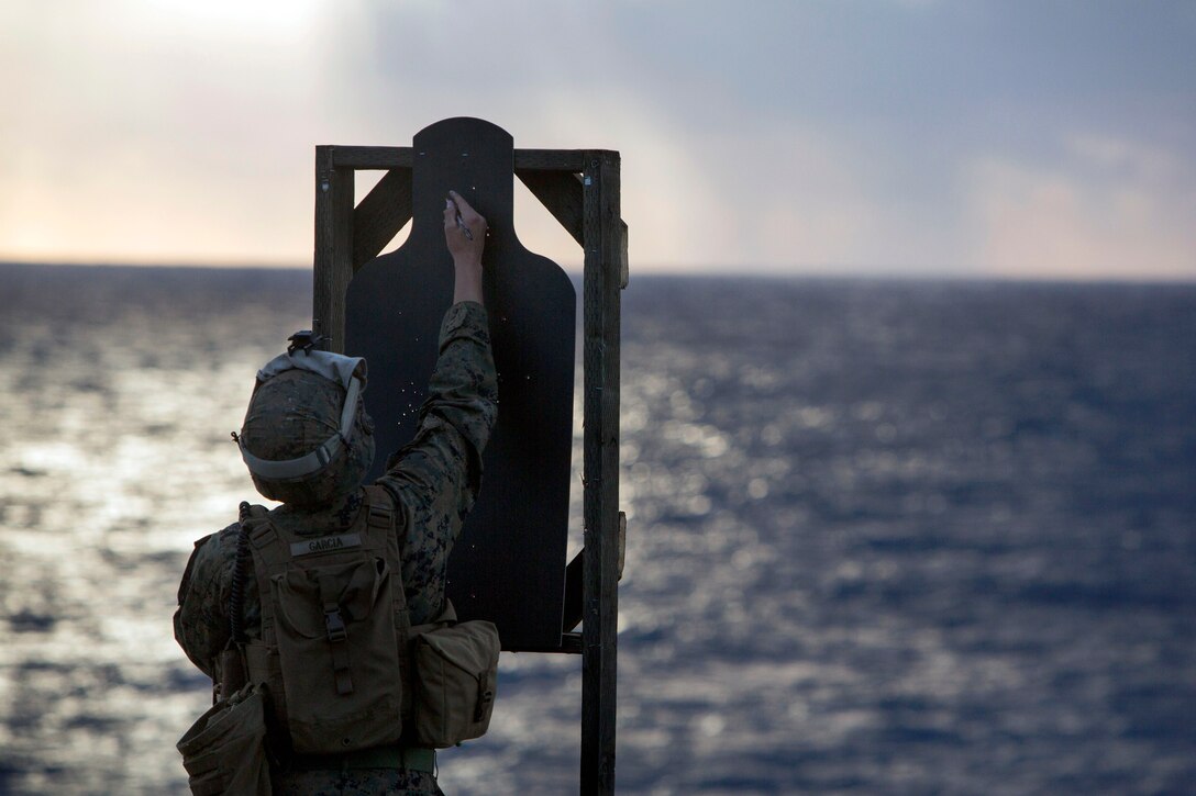 U.S. Marine Corps Cpl. Joshua Garcia marks a target during a live fire exercise on the flight deck of the USS Bonhomme Richard in the East China Sea, Feb. 10, 2015. Garcia is assigned to Battalion Landing Team, 2nd Battalion 4th Marines, 31st Marine Expeditionary Unit.