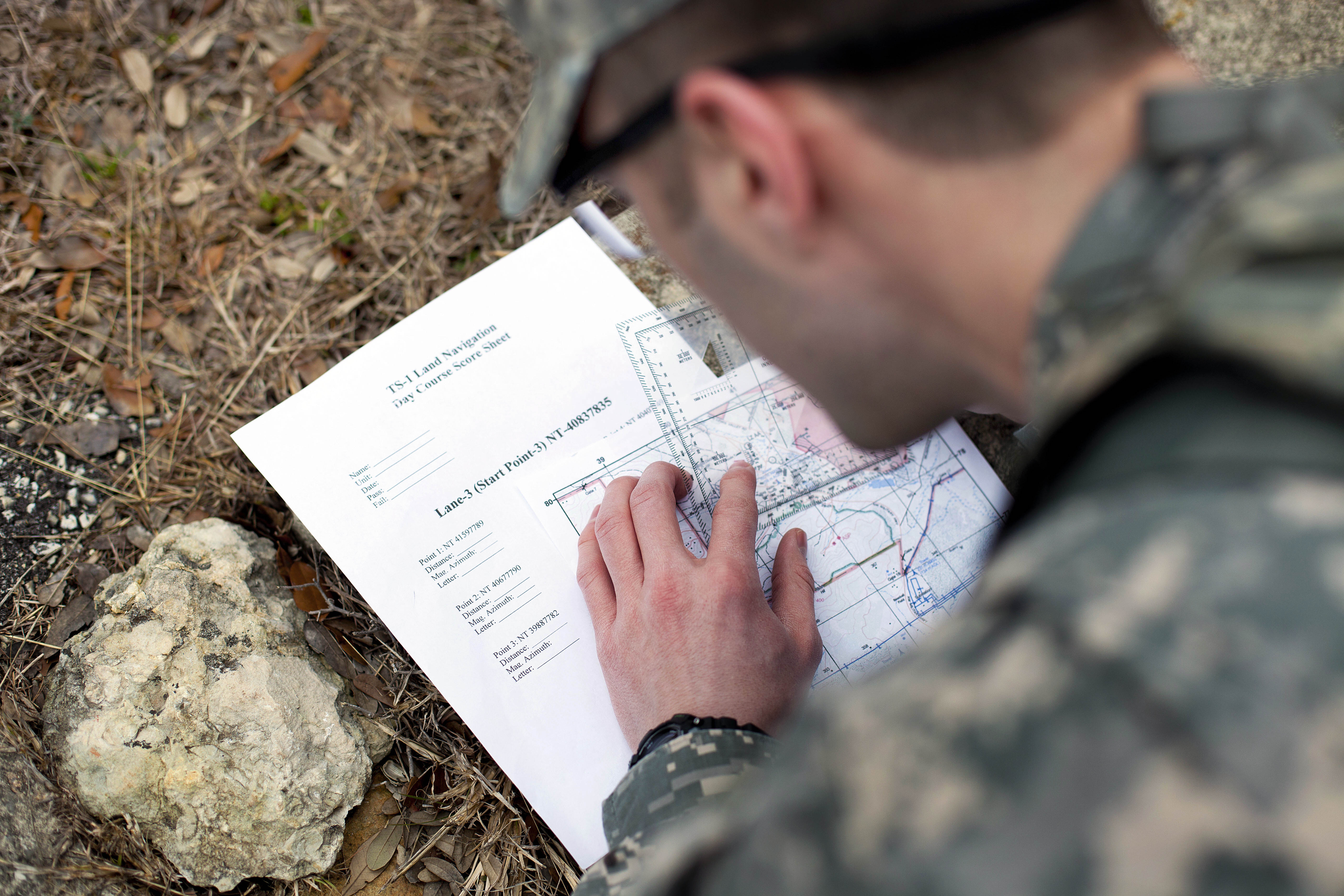 Army staff sgt jordan stubblefield plots a grid on a map during the land navigation portion of 