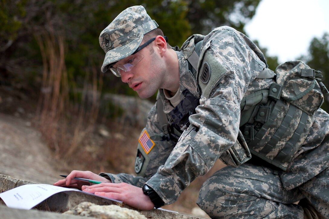 Army Staff Sgt. Jordan Stubblefield plots his next location on a map during the land navigation portion of the Texas Military Forces Best Warrior Competition on Camp Swift near Bastrop, Texas, Feb. 6, 2015. Stubblefield is assigned to the 80th Training Command.