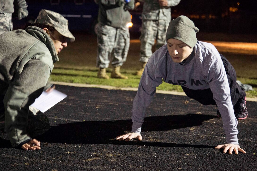 Army Spc. Rachel Anne Bower, right, competes in a push up during the ...