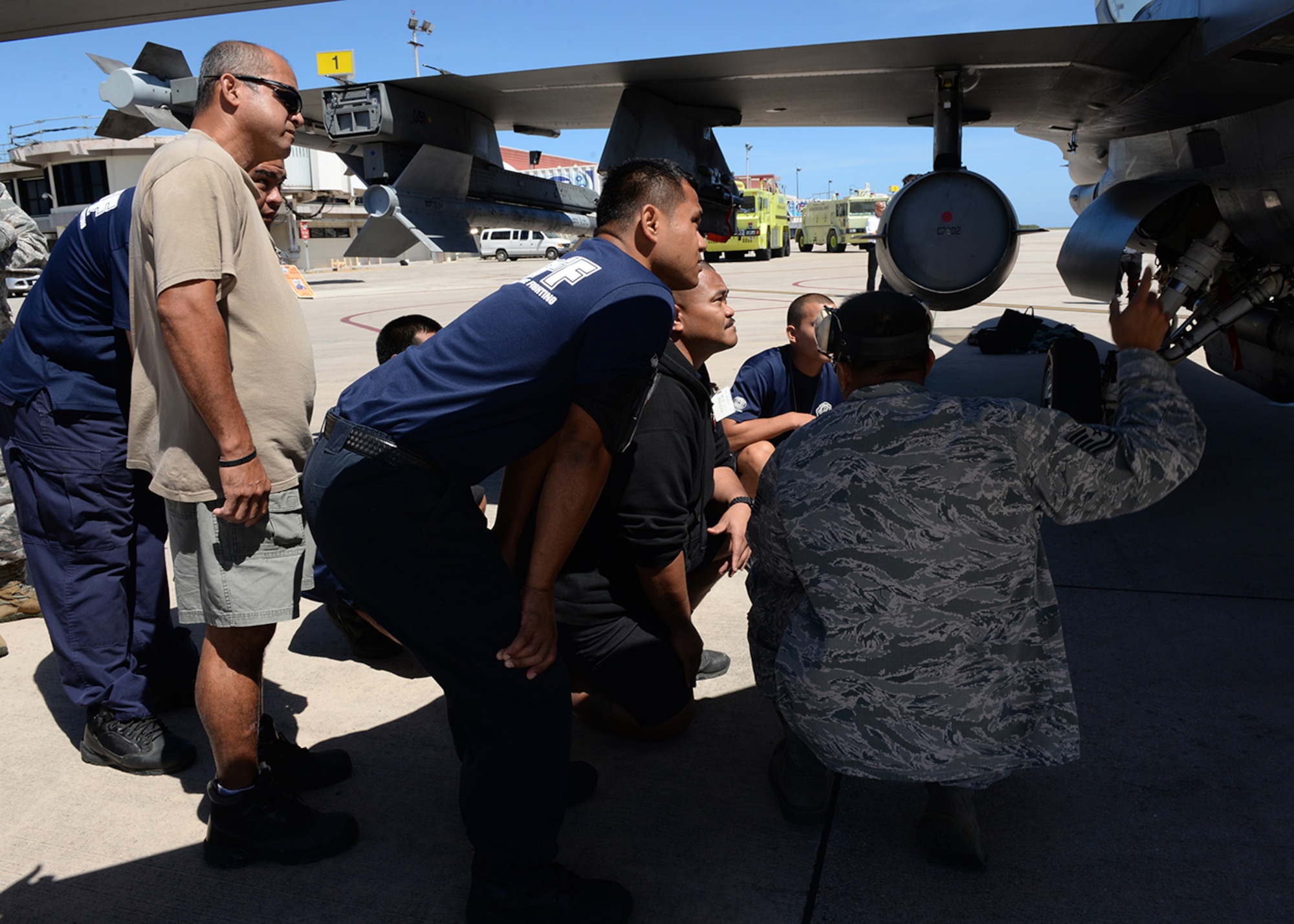 Tech Sgt. Arnell Dorn shows Saipan firefighters different parts of an F-16 Fighting Falcon during training Feb. 12, 2015, at the Saipan International Airport in the Commonwealth of Northern Marianas Islands. Since the F-16 is one of the aircraft used in aviation training relocation events, this training was geared towards preparing Saipan first responders for a runway emergency involving the F-16. Arnell is the Andersen Fire Department assistant chief of training. (U.S. Air Force photo/Senior Airman Cierra Presentado)