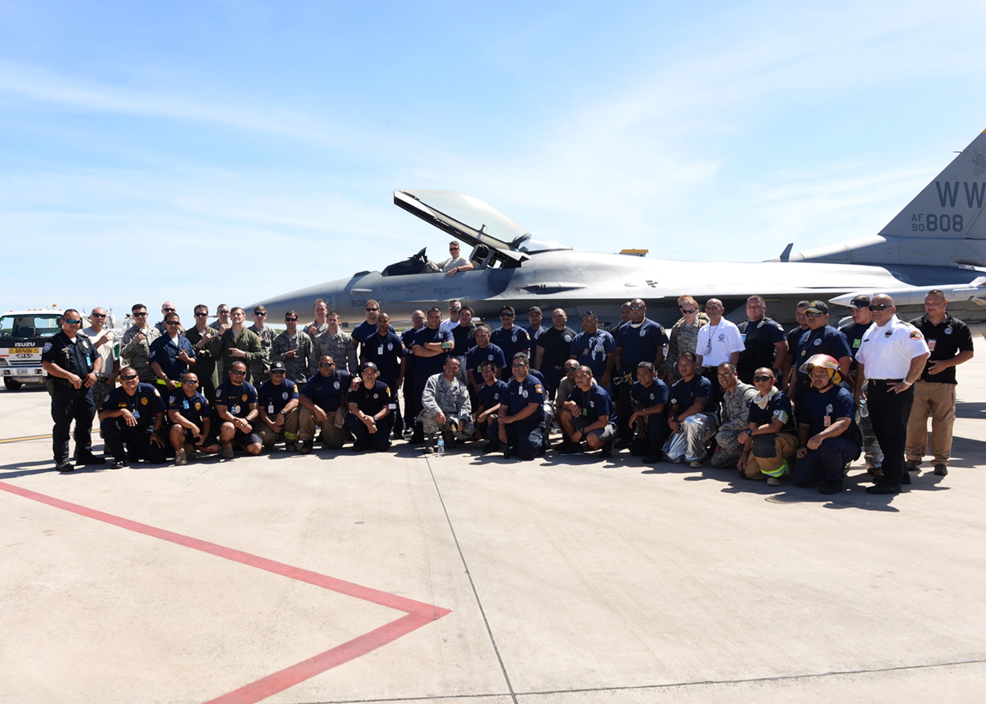 Members of Andersen Air Force Base, Guam, Saipan International Airport firefighters and F-16 pilots and maintainers deployed from the 35th Wing, Misawa Air Base, Japan, gather for a picture after training Feb. 12, 2015, at Saipan International Airport, Saipan in the Commonwealth of Northern Marianas Islands. The training was geared towards preparing Saipan first responders for a runway emergency involving the F-16. (U.S. Air Force photo/Senior Airman Cierra Presentado)