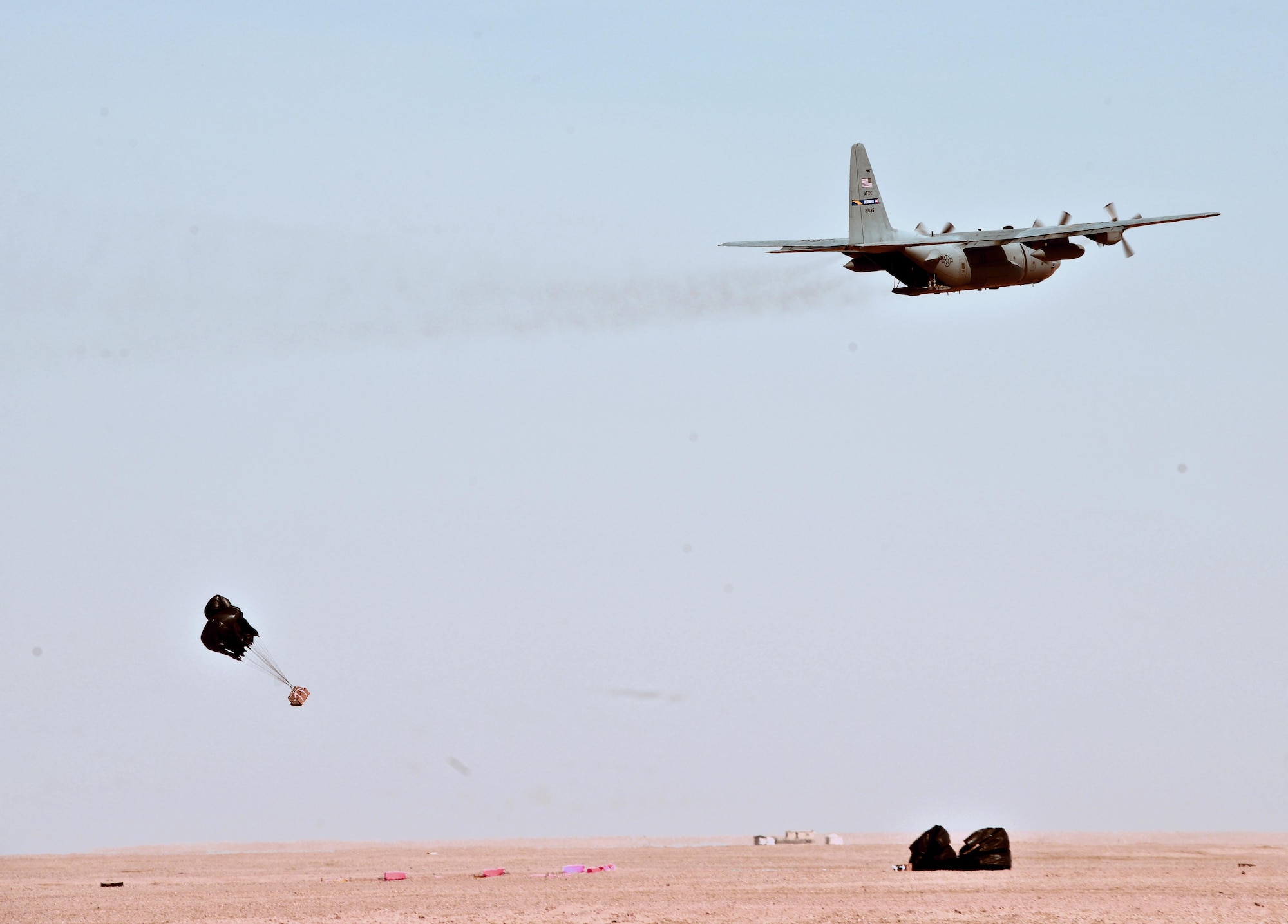 SOUTHWEST ASIA - A C-130 from the 737th Expeditionary Airlift Squadron drops a pallet during drop zone control officer training Feb. 10, 2015. The training helped Airmen from the 82nd Expeditionary Air Support Operations Squadron practice calling in aircraft for resupply drops. (U.S. Air Force photo by Tech. Sgt. Jared Marquis/released)