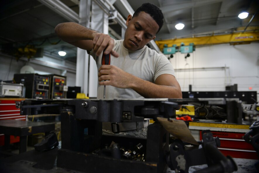 Senior Airman Anthony Mulero, 51st Munitions Squadron F-16 armament systems technician, loosens a bolt on a bomb rack during a routine inspection Feb. 10, 2014, at Osan Air Base, Republic of Korea. F-16s are inspected for their 20-mm gun, air-to-air missiles, conventional air-to-air and air-to-surface munitions and electronic countermeasure pods. (U.S. Air Force photo by Senior Airman David Owsianka)
