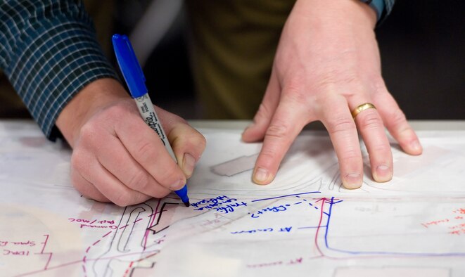 Aaron Briggs, HB&A lead planner, makes notes on a map during an Area Development Plan meeting with Team Dover members Jan. 20, 2015, at Dover Air Force Base, Del. Briggs and HB&A team members took input from stakeholders in four of 13 affected ADP areas during their two-week visit. (U.S. Air Force photo by Roland Balik)