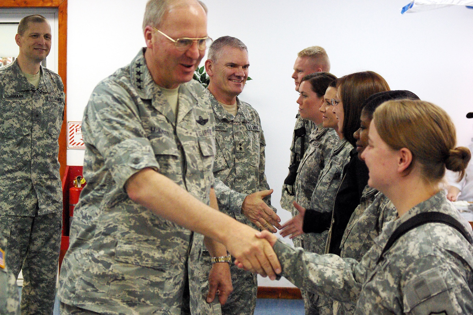 Air Force Gen. Craig McKinley, chief of the National Guard Bureau, and Army Maj. Gen. David Sprynczynatyk, the adjutant general of North Dakota, greet Soldiers at Camp Bondsteel's dining facility in Kosovo May 23, 2010.