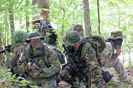 Georgia National Guard members gather at a rally point before moving on to their objective - a sparsely wooded area being used by simulated drug dealers for a simulated drug deal at Volunteer Training Site-Catoosa in Ringgold, Ga.