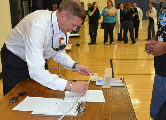 ALBUQUERQUE, N.M., -- Reginald Bourgeois, the District’s STEM coordinator and a judge at the 2015 Central New Mexico Regional Science Olympiad, measures a student’s plane Jan. 31. The planes had to meet specific minimum weight and size limits to be eligible to compete in “The Wright Stuff” event.