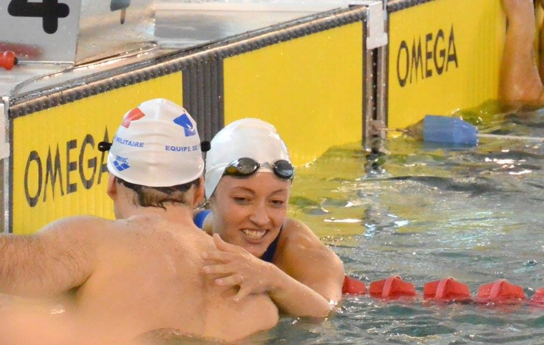 Army Sgt. Elizabeth Wasil (Ft. Carson, Colo.) is congratulated by Sgt. Francois-Xavier David of France after reaching to wall first to capture the gold medal in the 100m breaststroke in the CISM ISC para-swimming classification during the 2015 Conseil International du Sport Militaire (CISM) Swimming & Para-Swimming Open.
