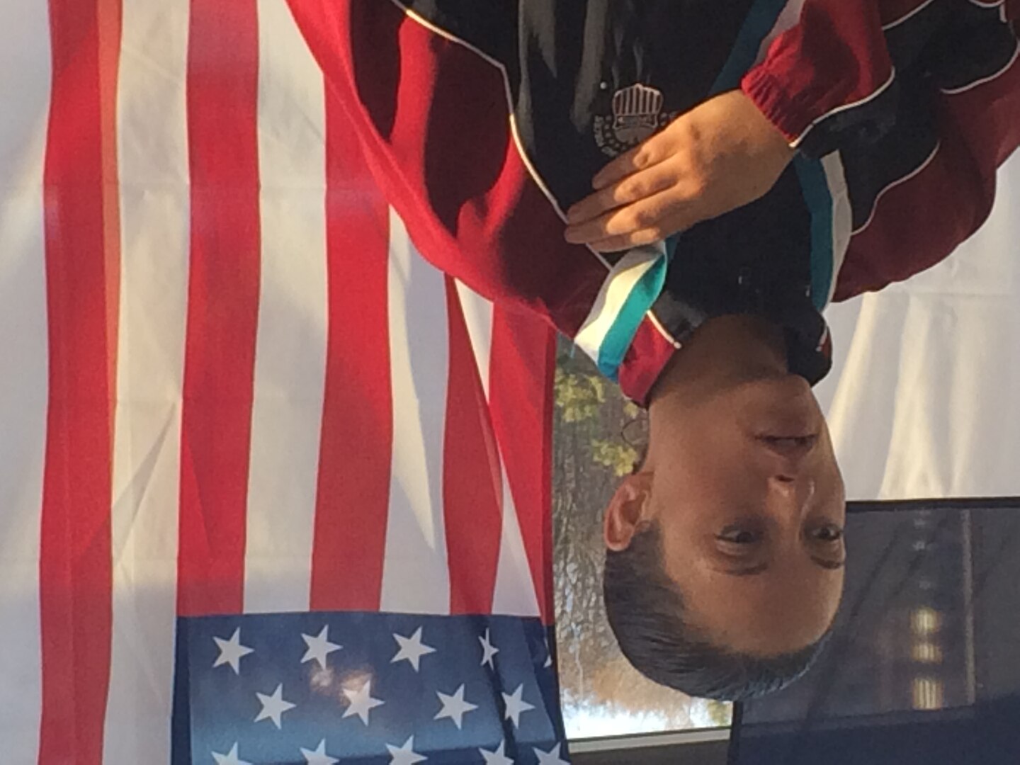 Army Sgt. Elizabeth Wasil (Ft. Carson, Colo.) stands on top of the podium as the Stars and Stripes are raised after being awarded the gold medal in the 100m breastsroke in the CISM ISC para-swimming classification during the 2015 Conseil International du Sport Militaire (CISM) Swimming & Para-Swimming Open.