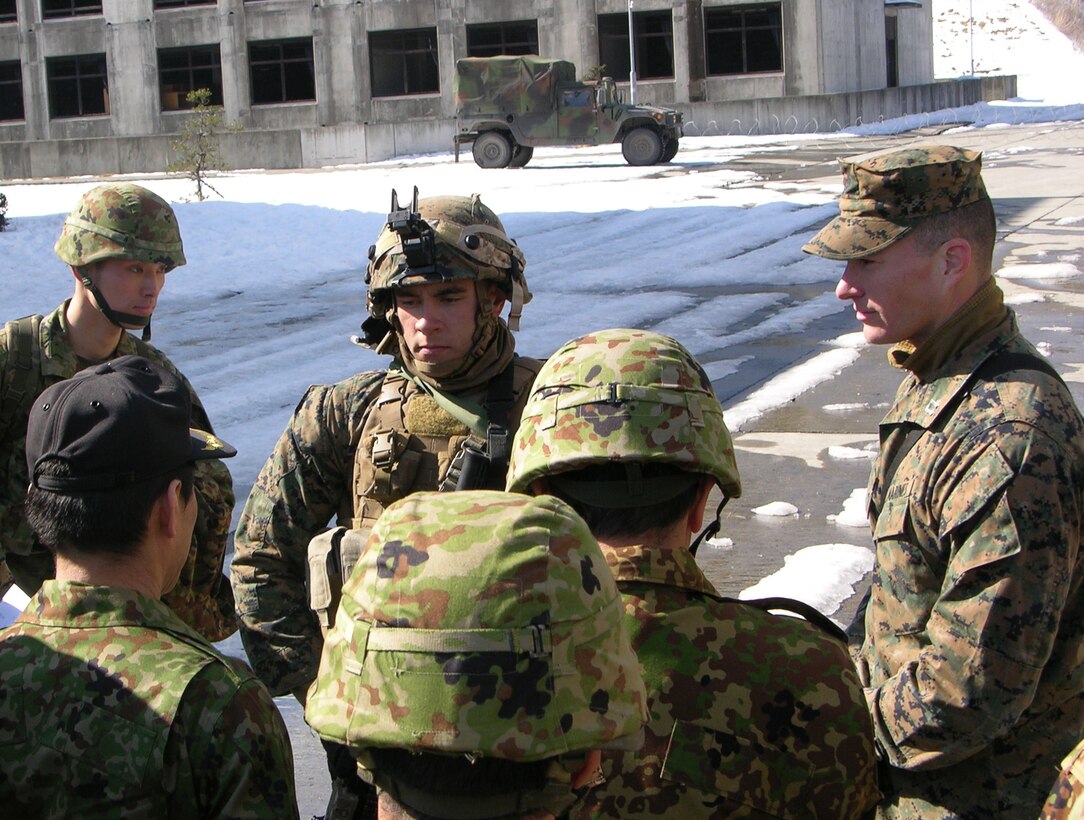 12 Feb 2015 - Camp Fuji, Gotemba, Shizuoka Pref., Japan - Capt Hotvet (LAR Co., CAB, 3d MarDiv) provides an overview of LAR training being conducted at the Military Operations on Urban Terrain Facility, Fuji Maneuver Area to JGSDF Colonel Nakamoto and Colonel Aso.